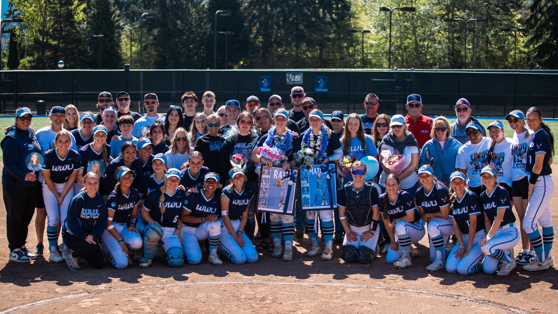 Softball Senior Day Recap | Group photo of softball players and families on a softball field