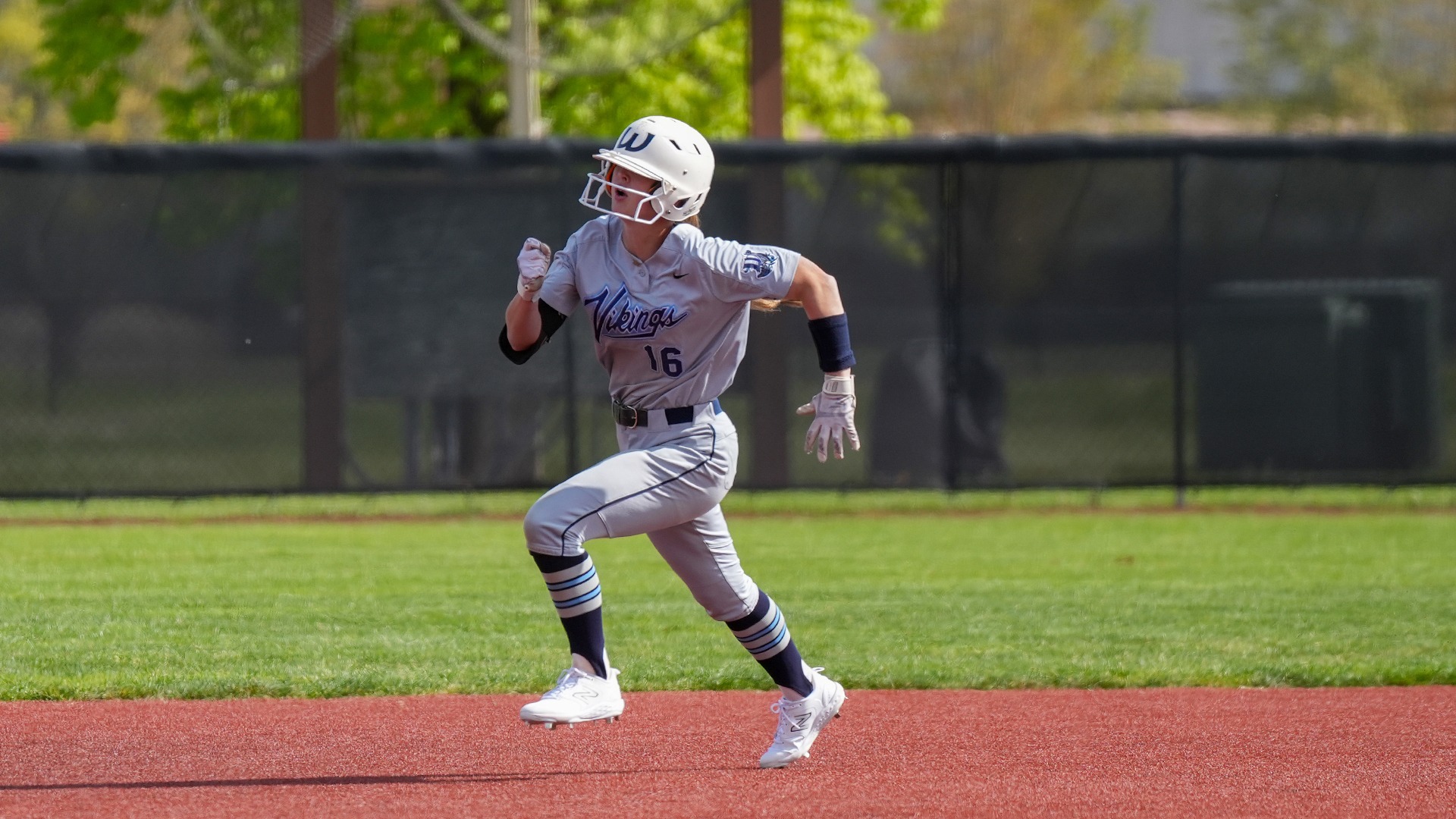 Laila Carpenter | WWU Softball player running bases in a gray uniform