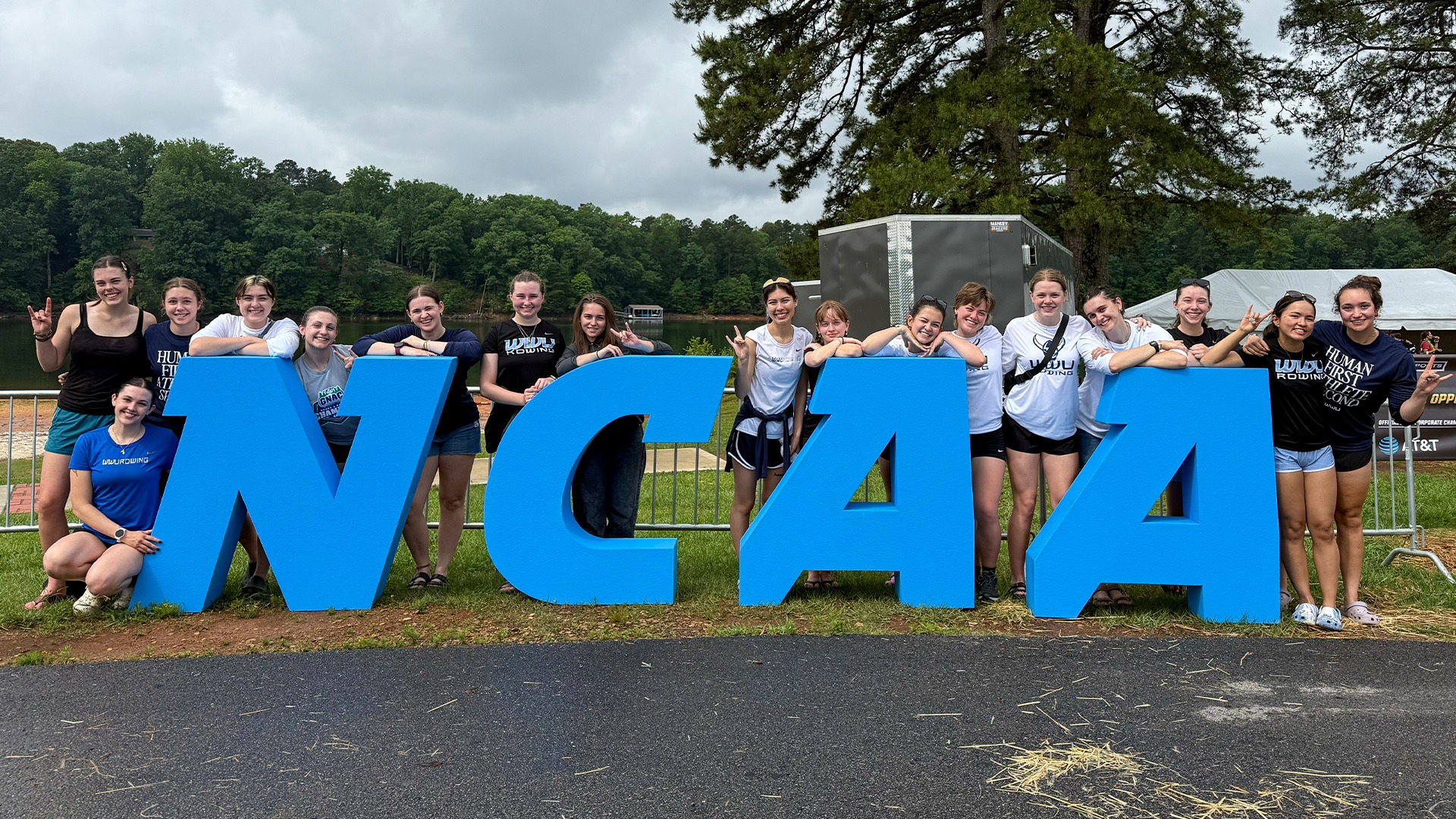 Photo of WWU Rowing at NCAA Championships in front of block N-C-A-A letters