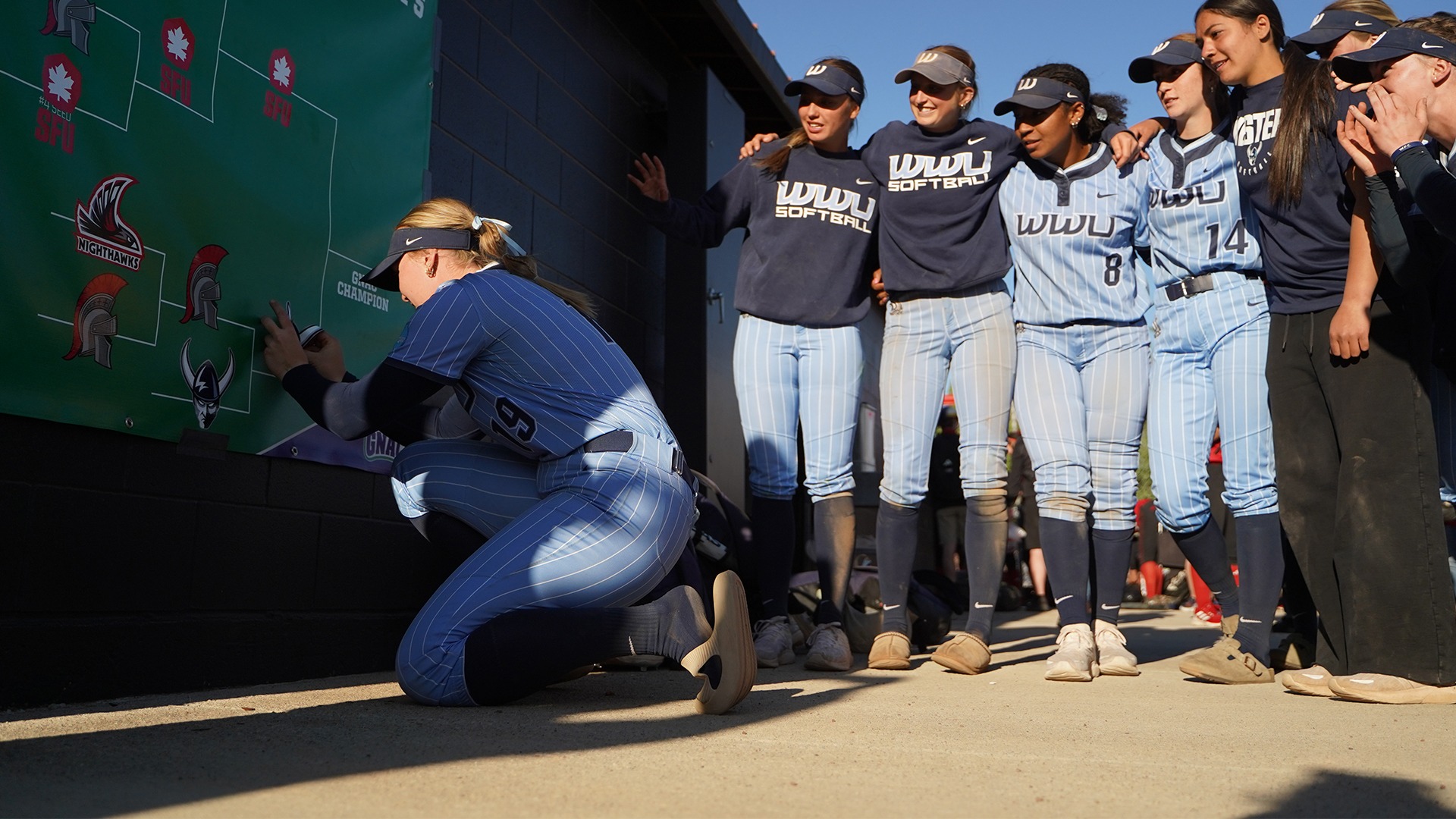Olivia Matlock places a sticker on a bracket with her team looking on