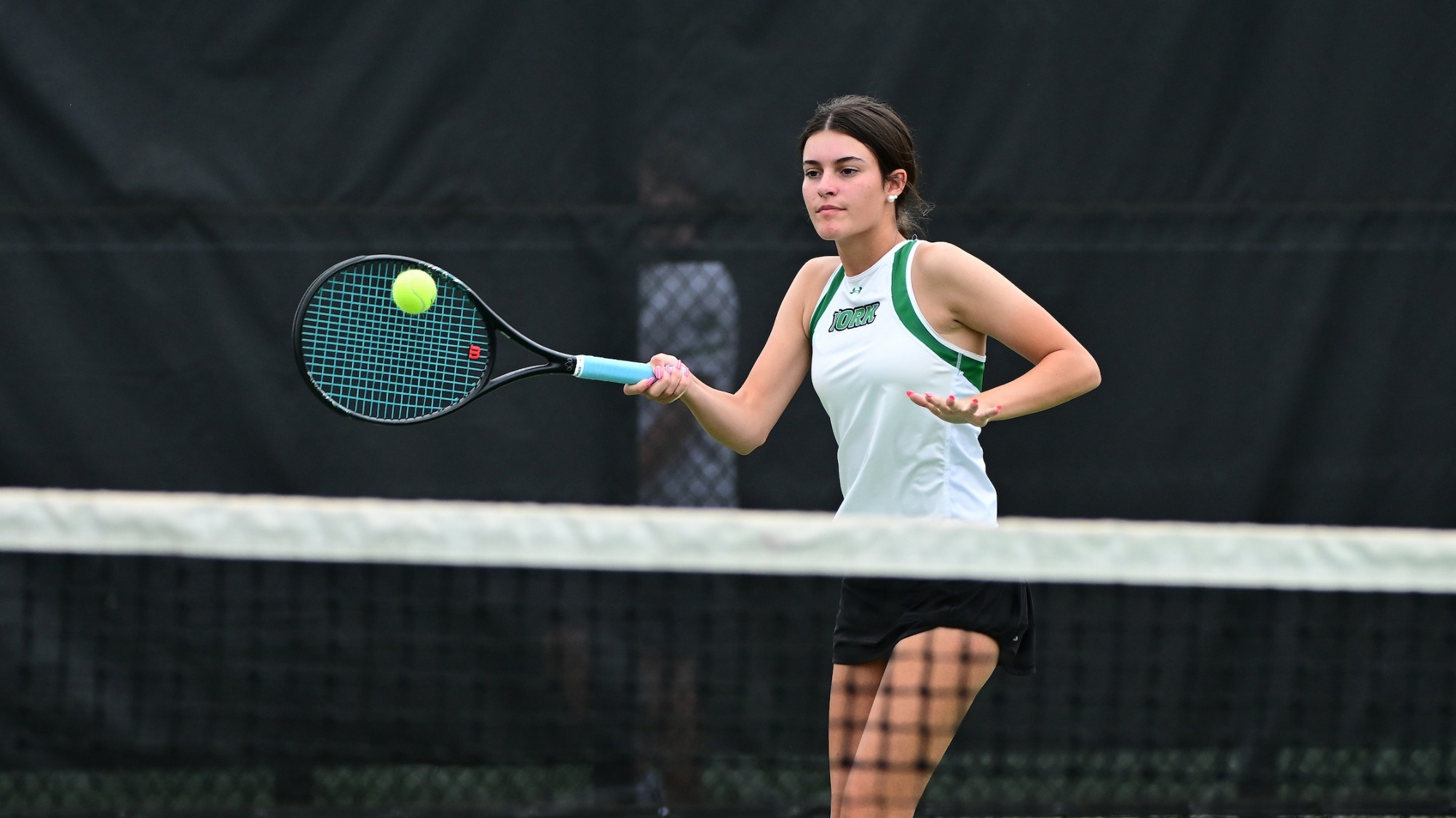 female tennis player strikes a forehand shot