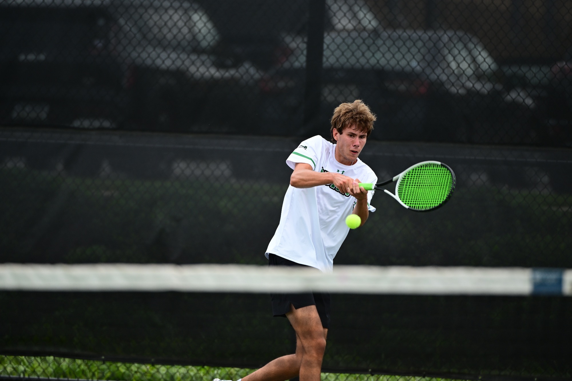 Male hitting tennis ball