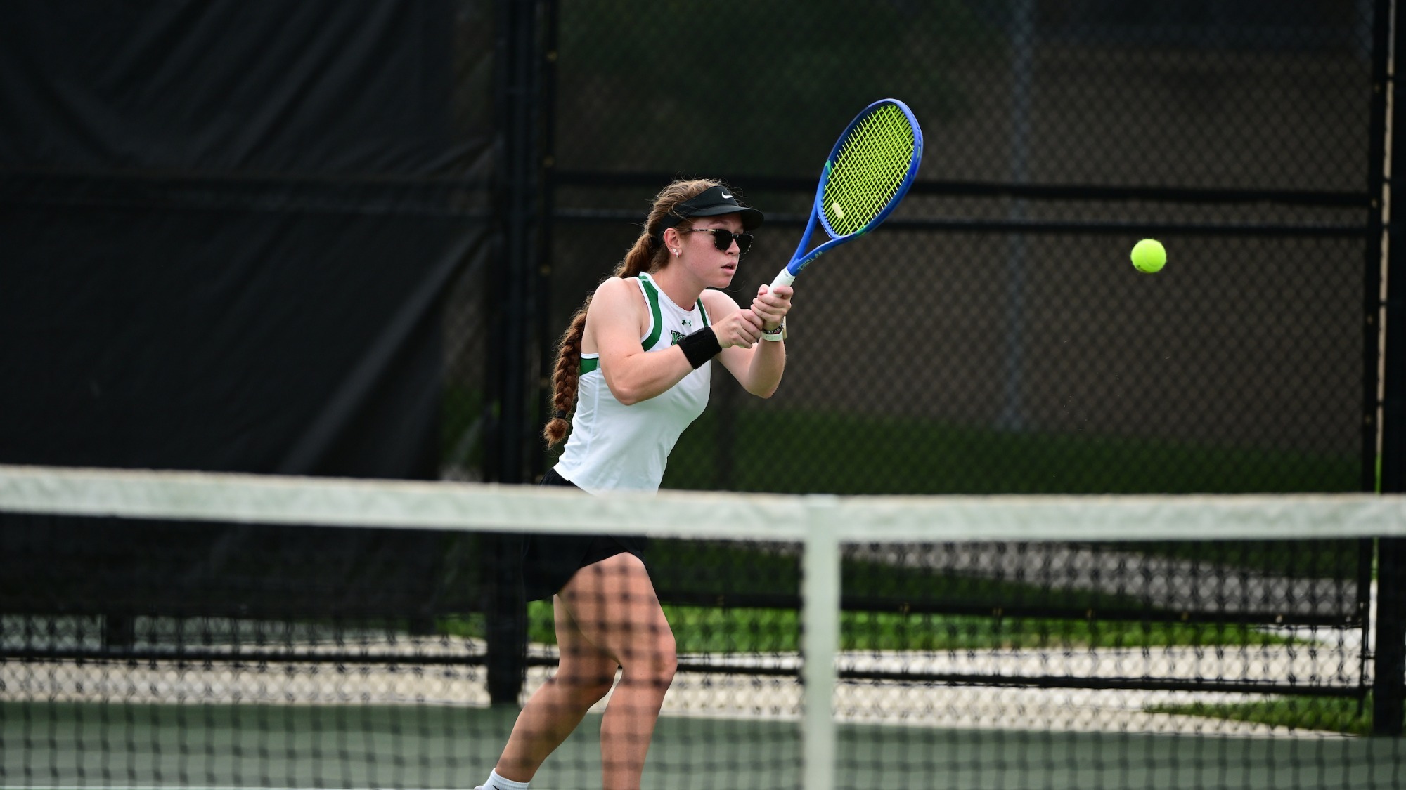 female tennis player hits a back hand
