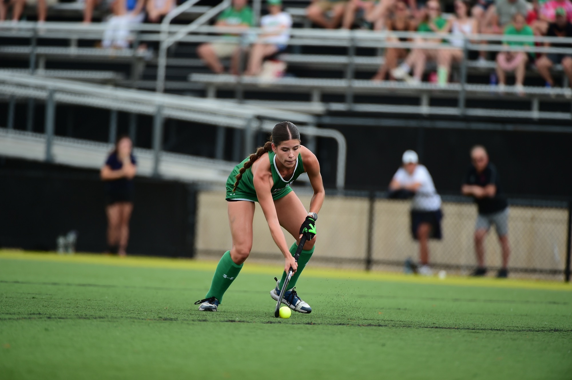 Female running with field hockey stick