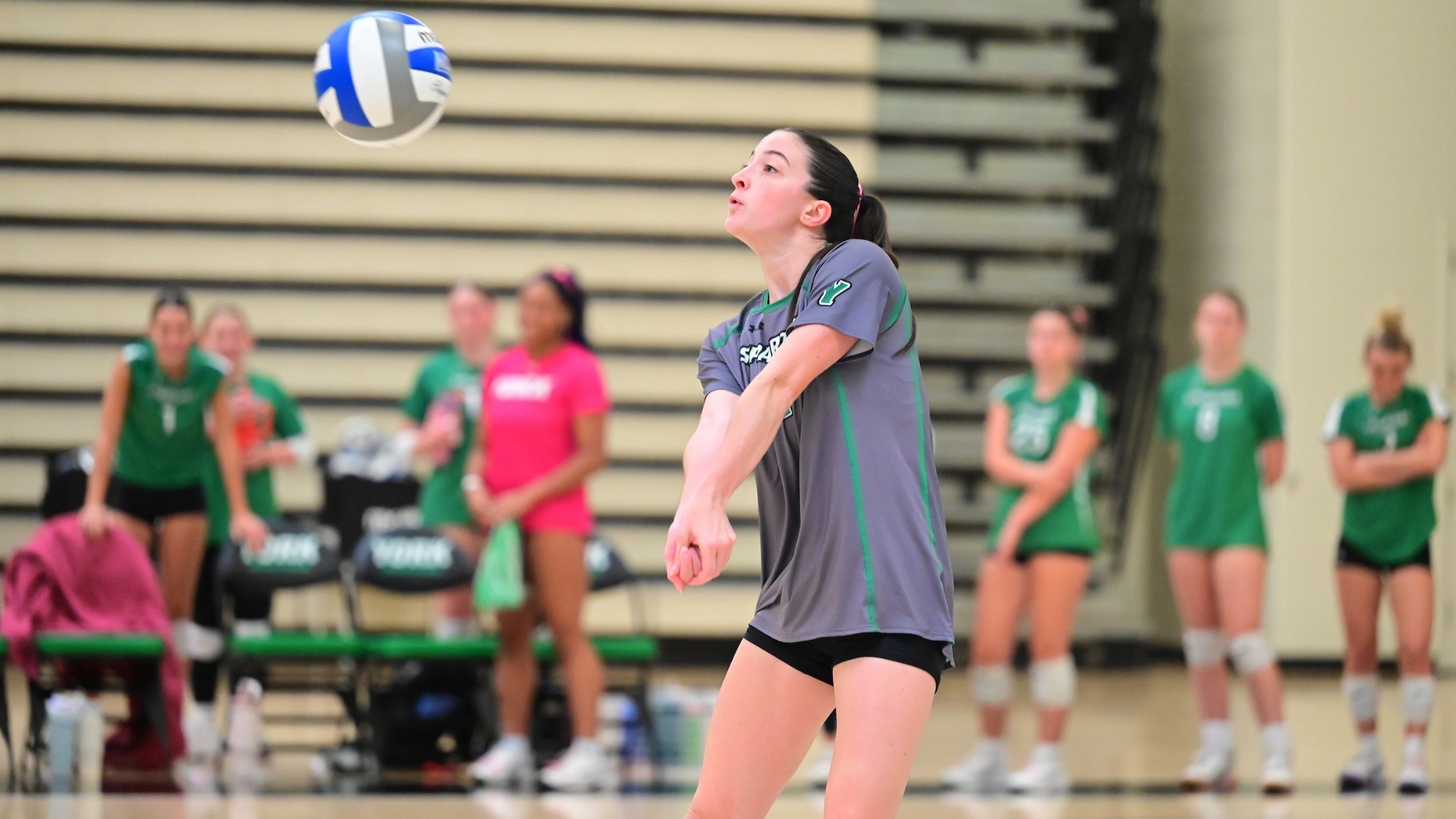 female volleyball player digs a ball