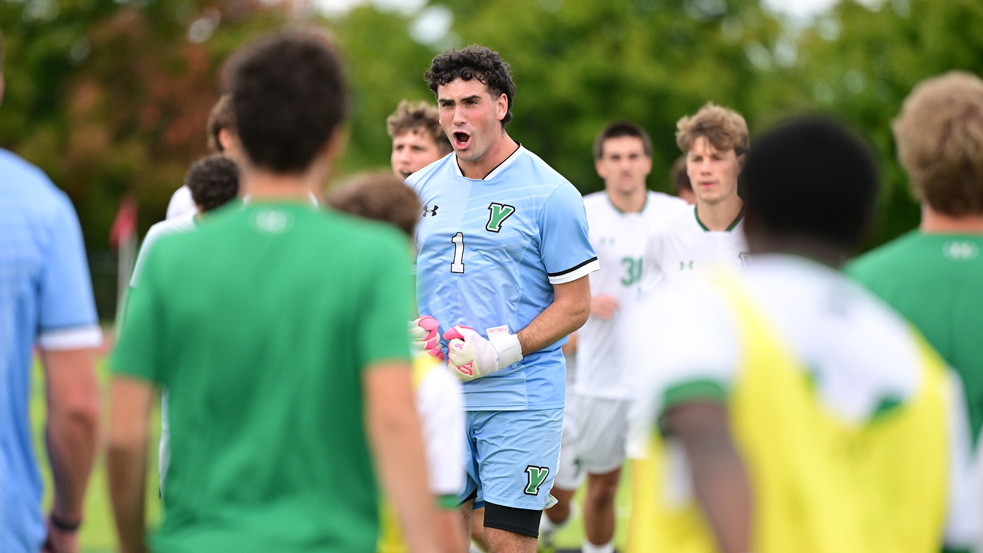 male soccer goalie celebrates with teammates