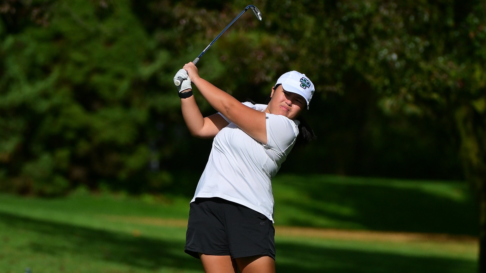 female golfer holds follow through