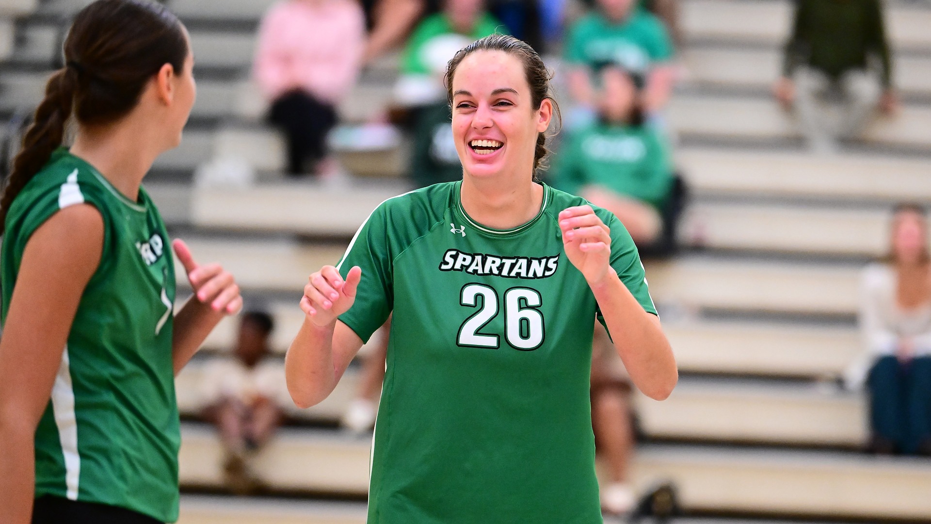 female volleyball players celebrates with teammate