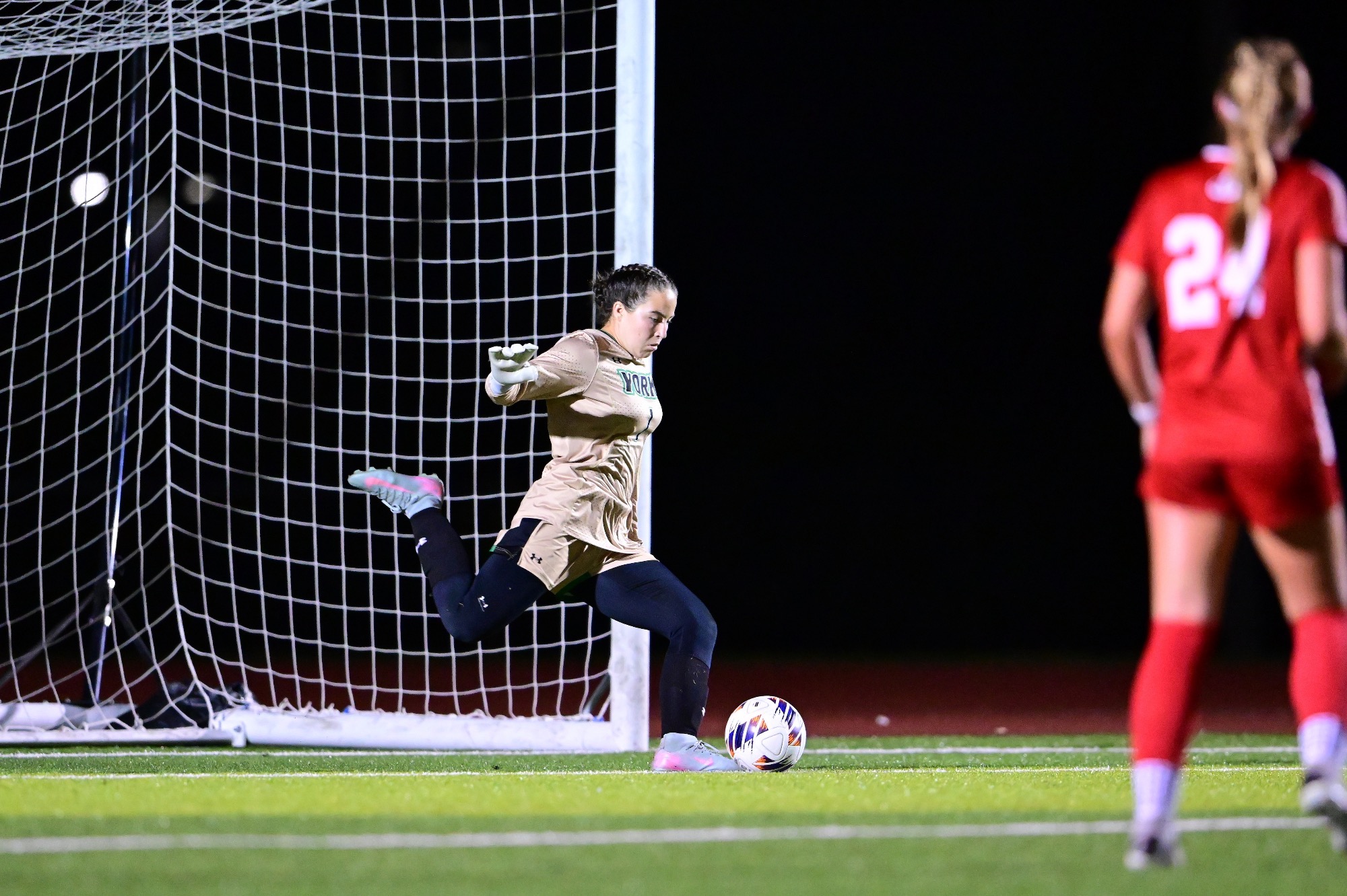 Female goalkeeper kicking ball