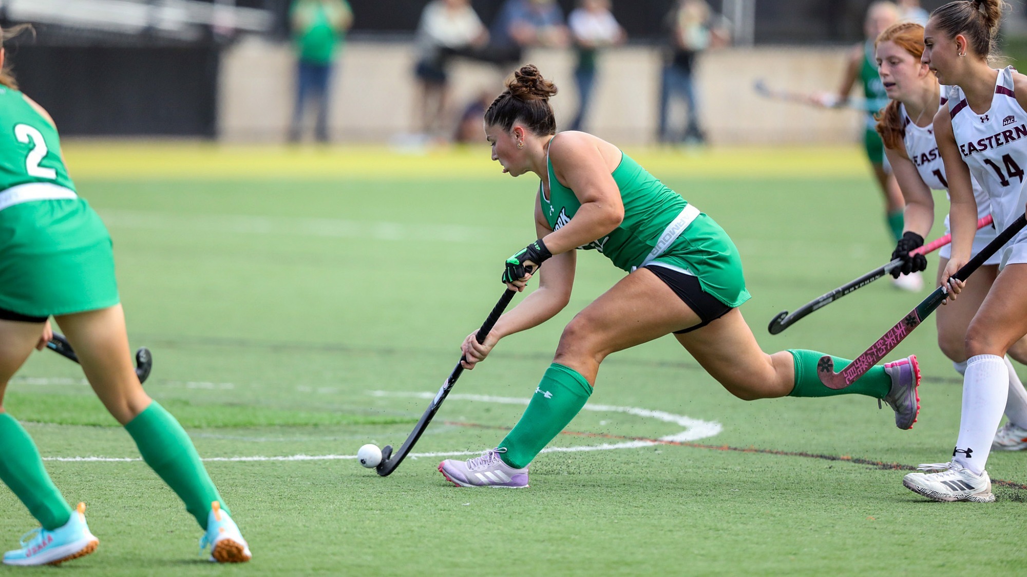 female field hockey player shoots on goal
