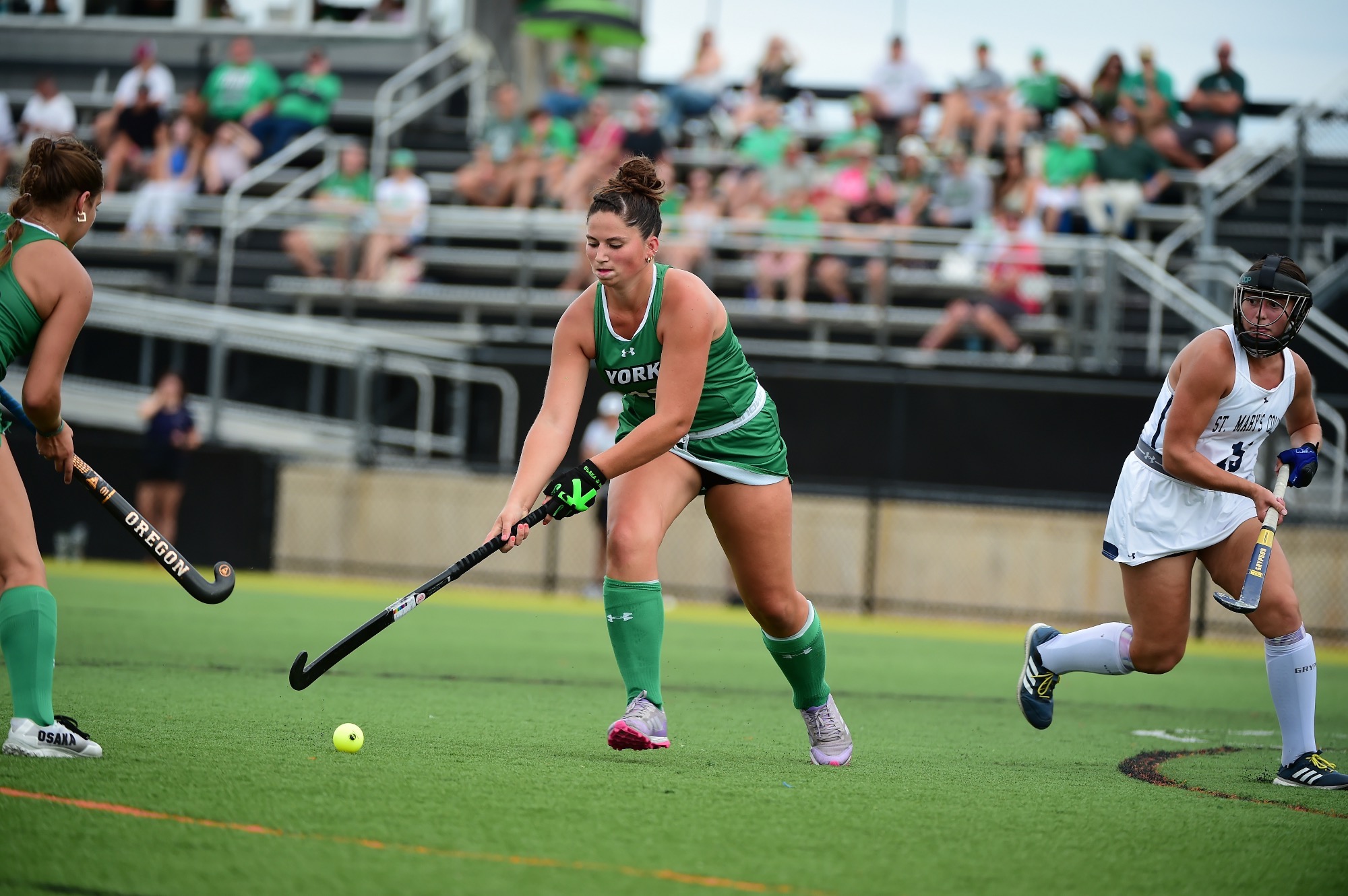 Female running with field hockey stick