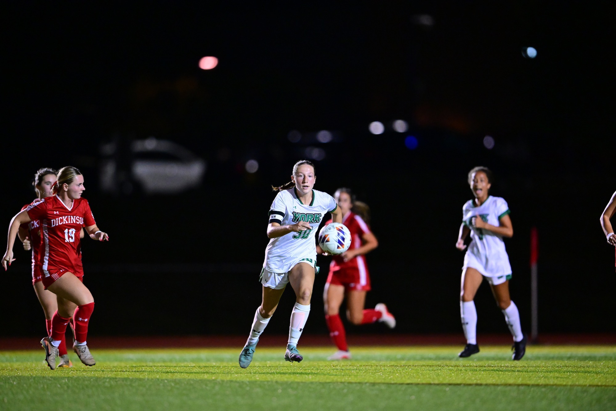 female running after soccer ball