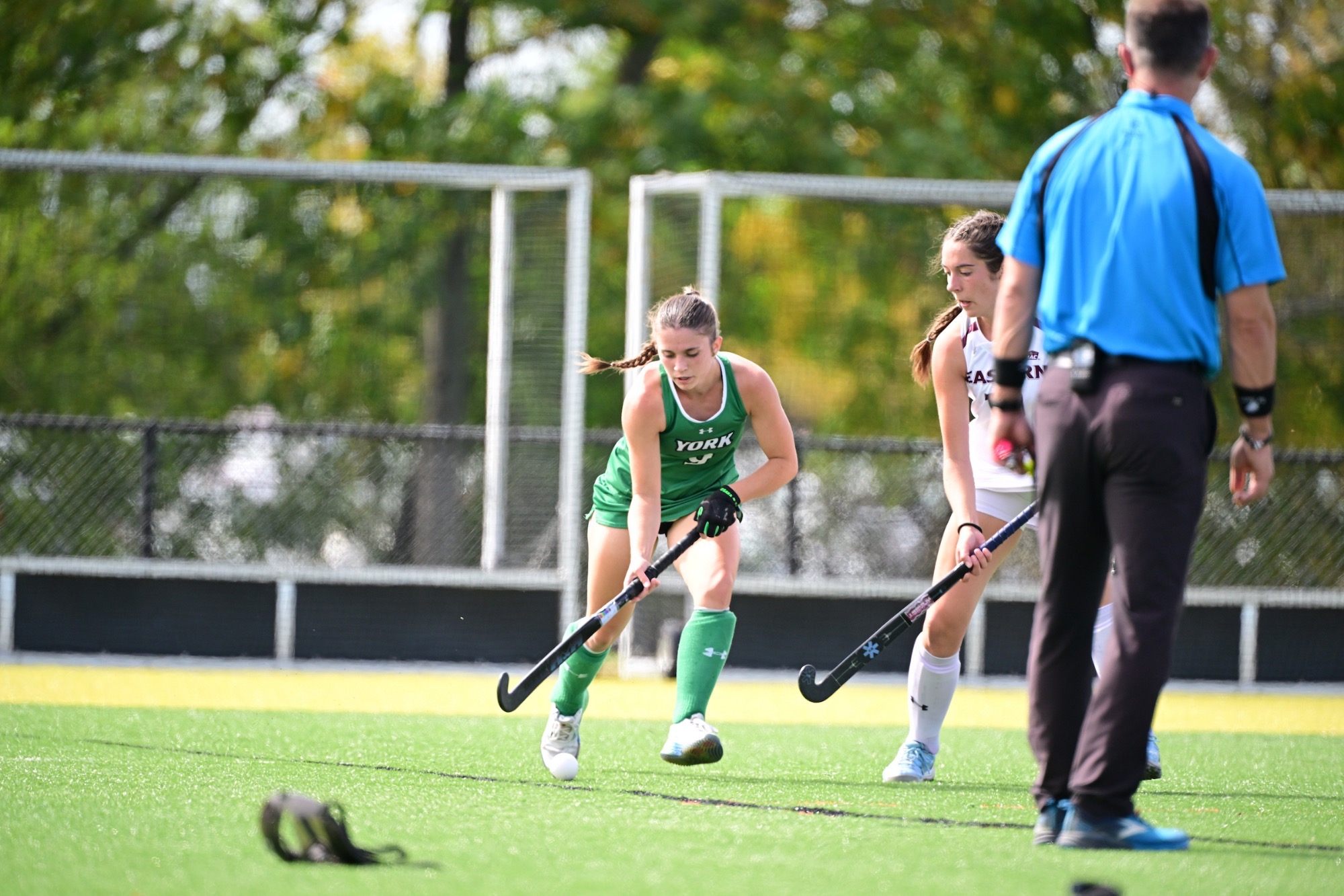 Female running with field hockey stick