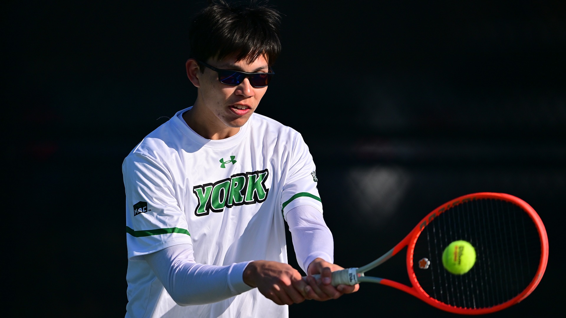 male tennis player hits ball