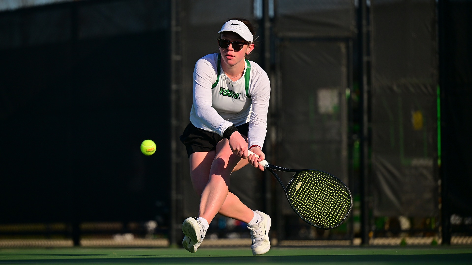 female tennis player hits ball