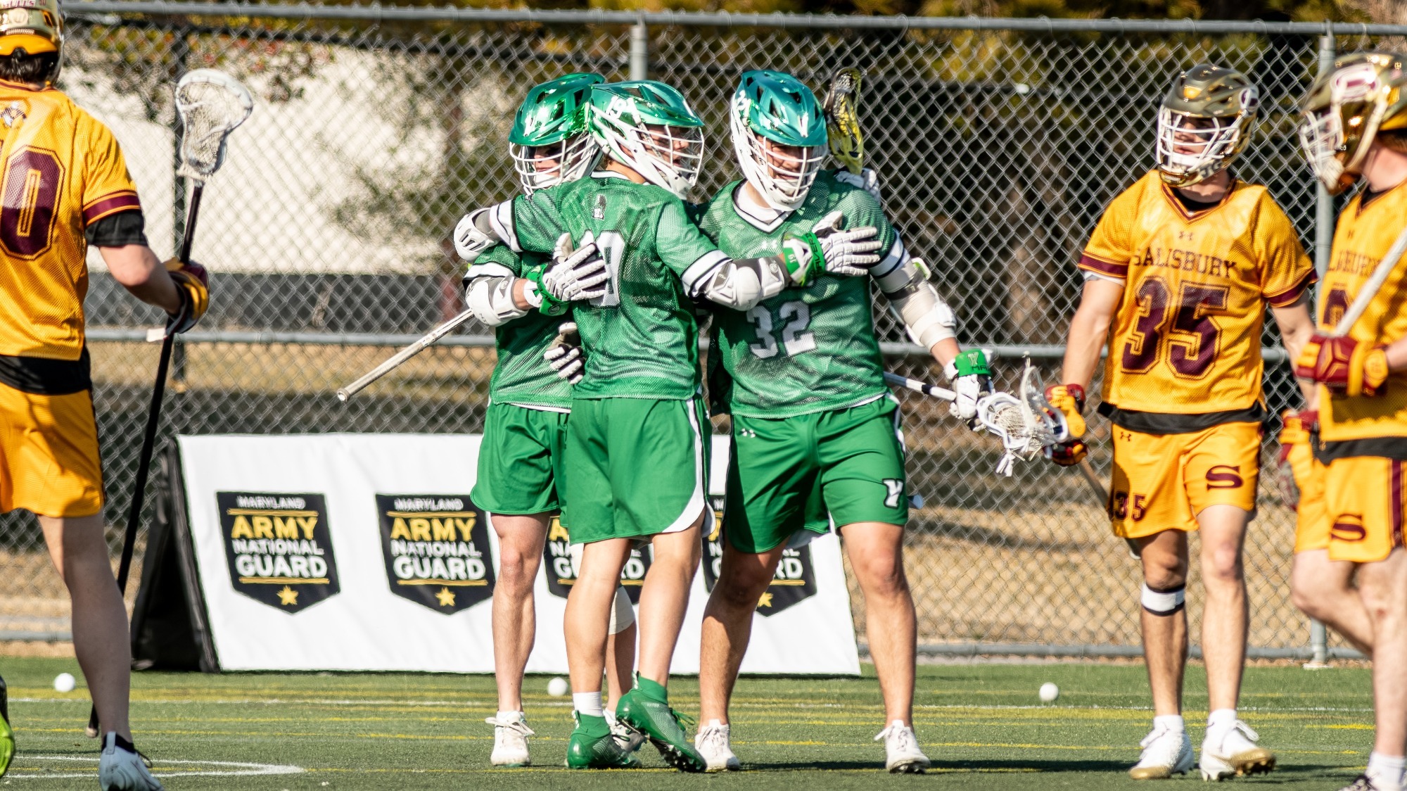 male lacrosse players celebrate goal