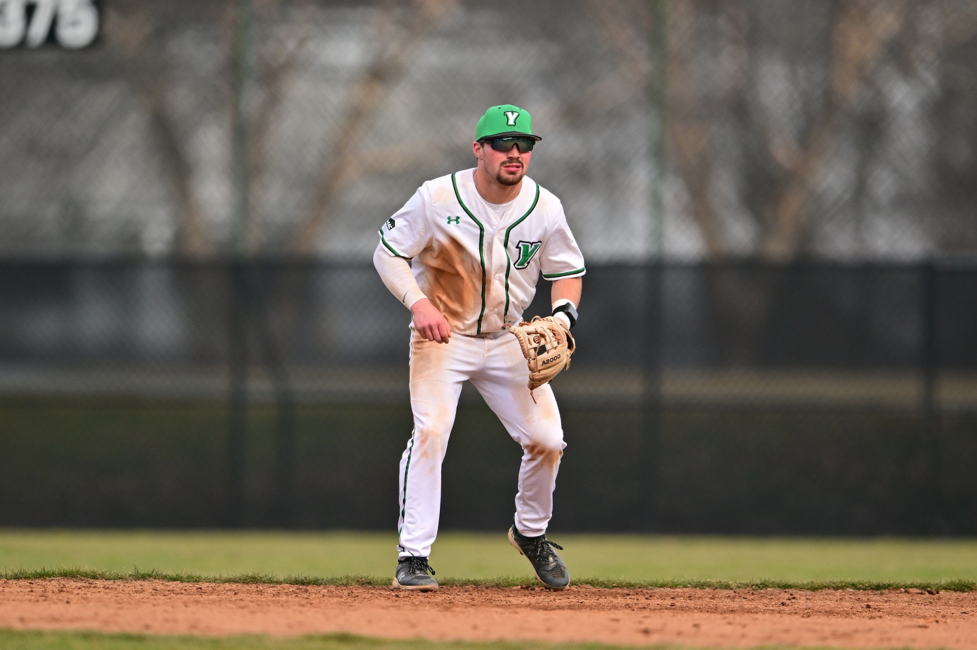 Male in white uniform in fielding position