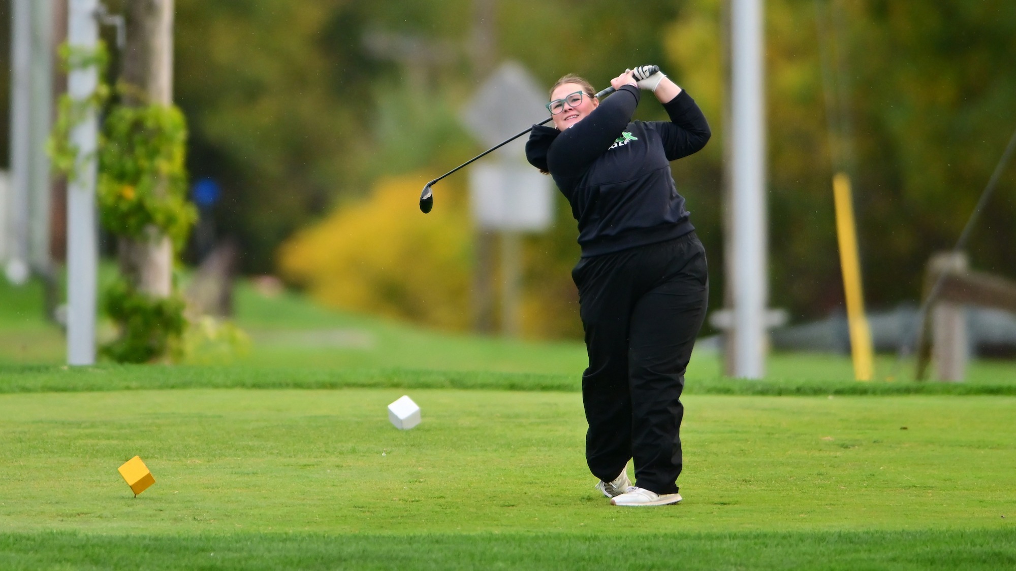 female golfer follows tee shot