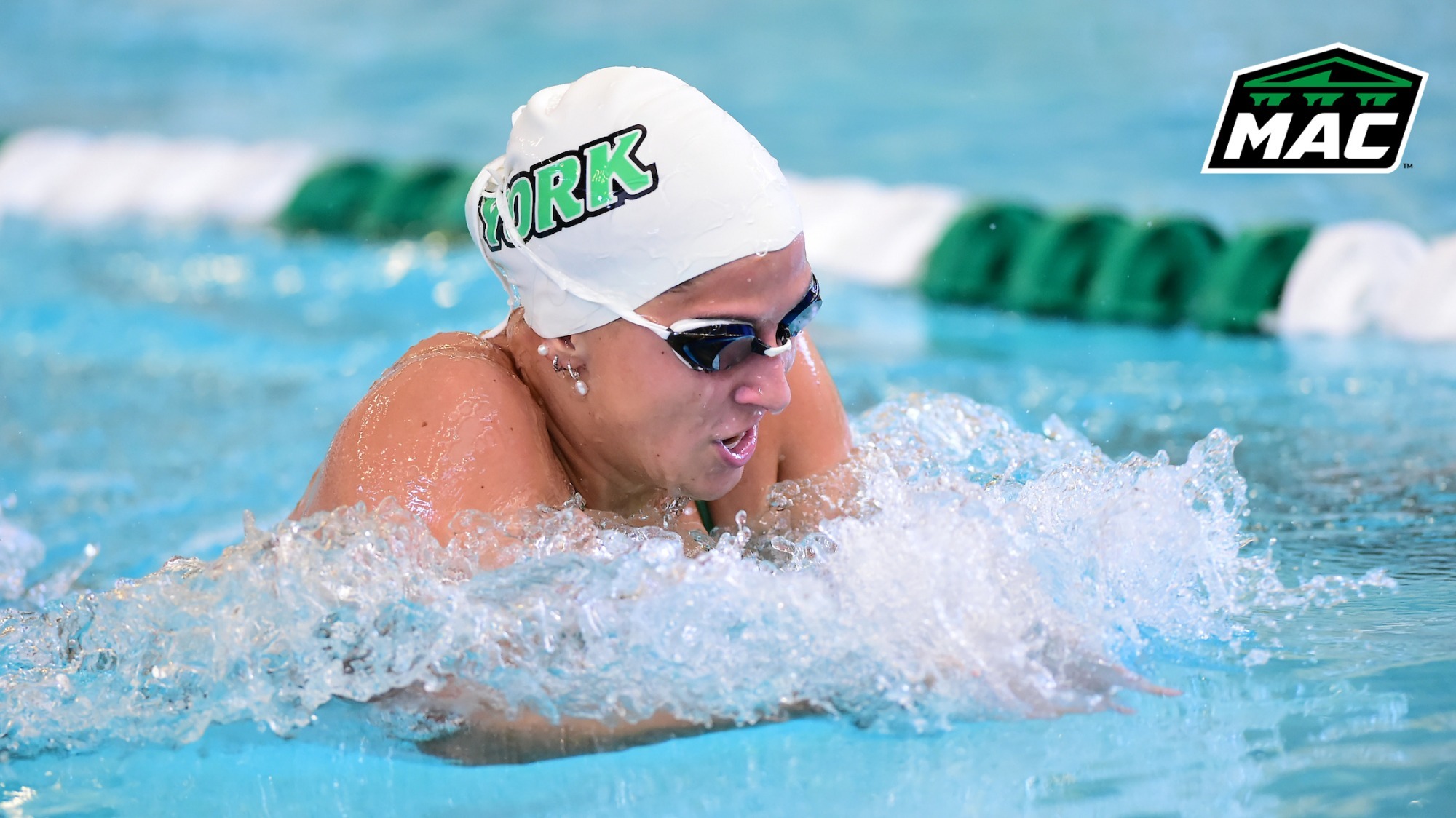 female swimmer competes in breaststroke with MAC logo in upper right