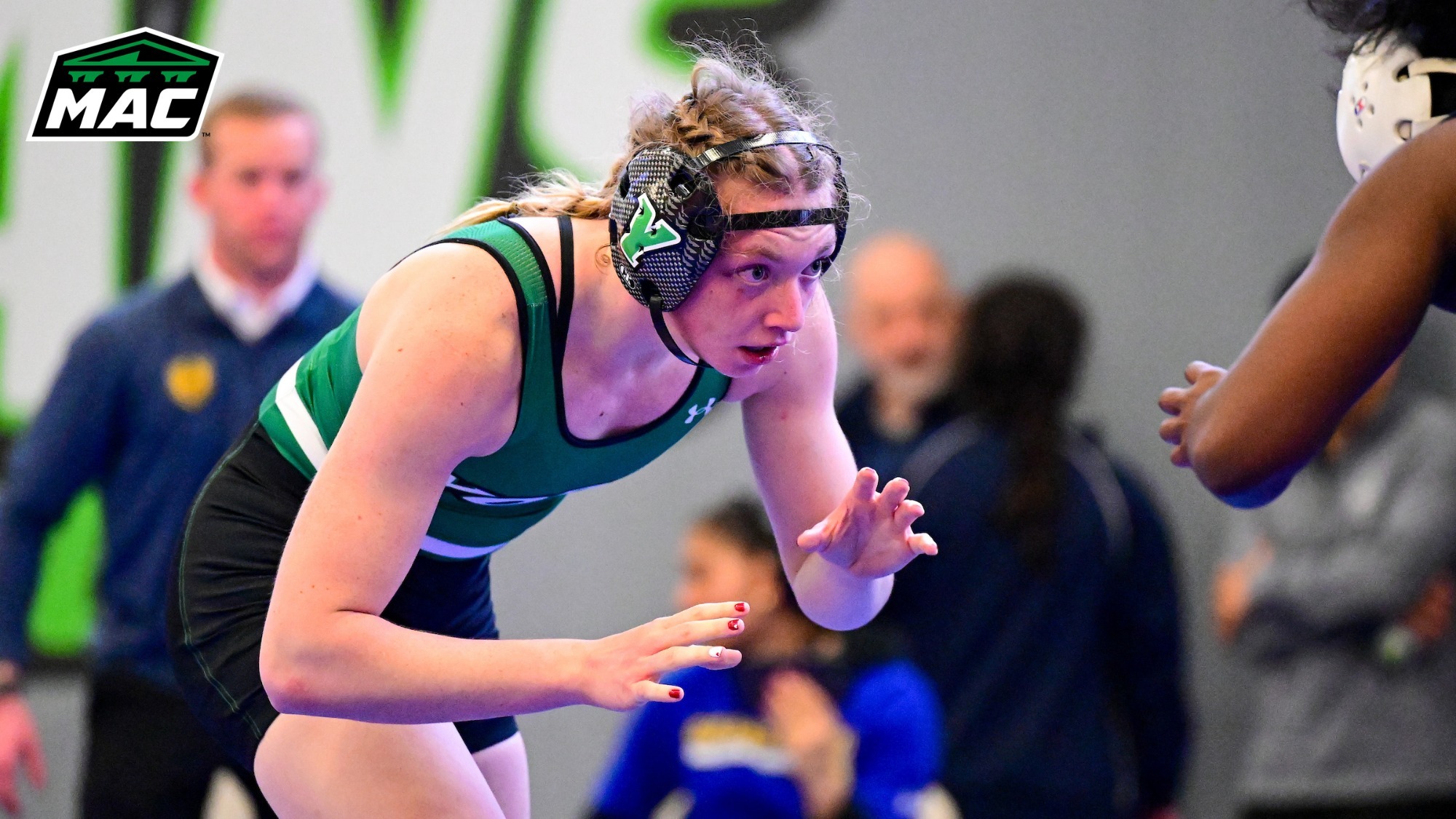 female wrestler stalks opponent with MAC logo in upper left corner