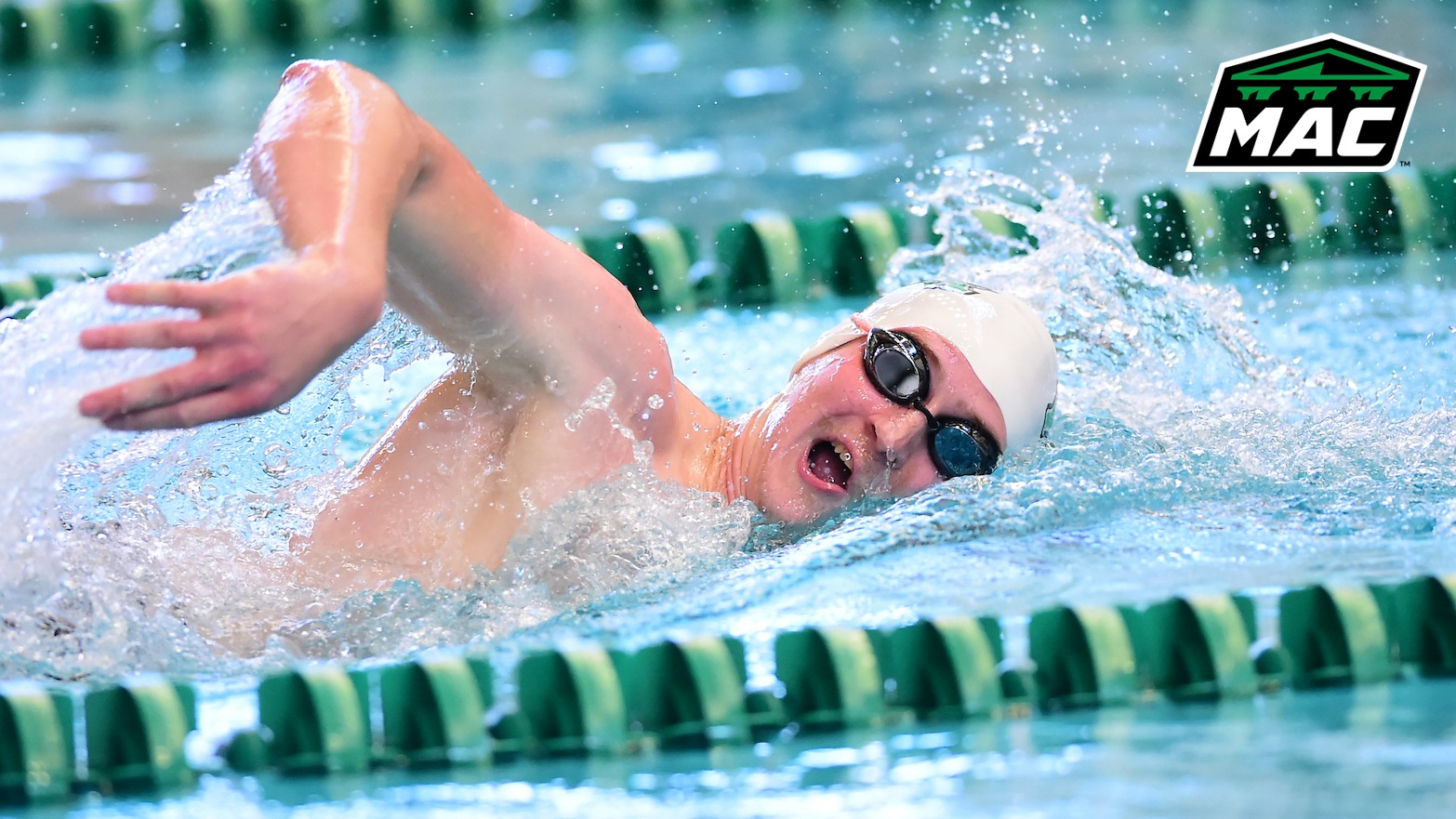 male swimmer competes in freestyle with MAC logo in upper right corner
