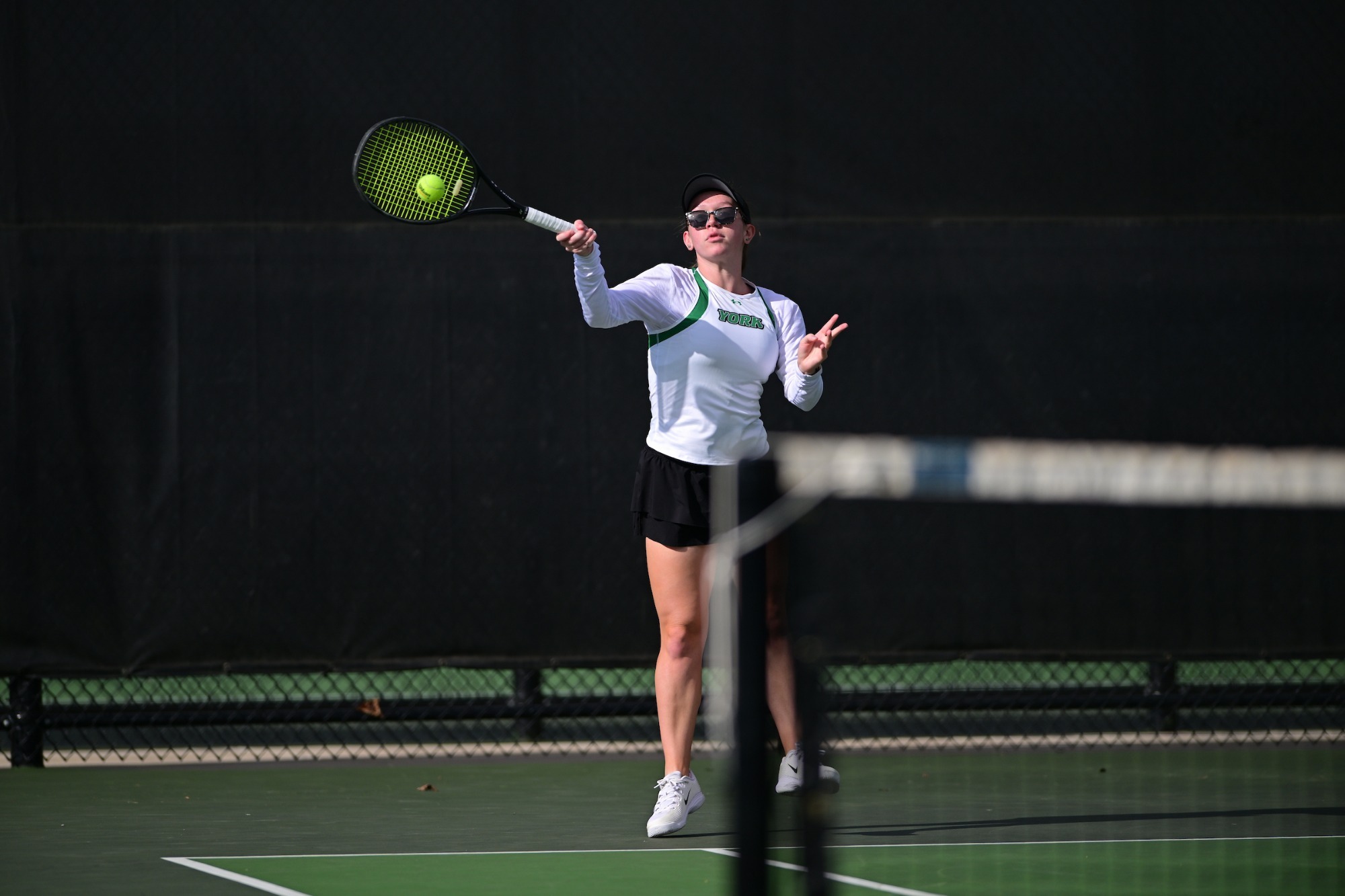 female tennis player hits ball
