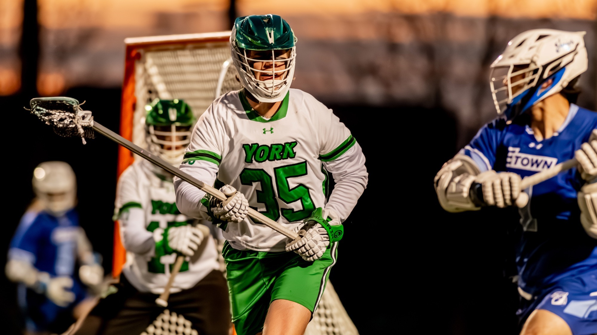 male lacrosse player defends opponent