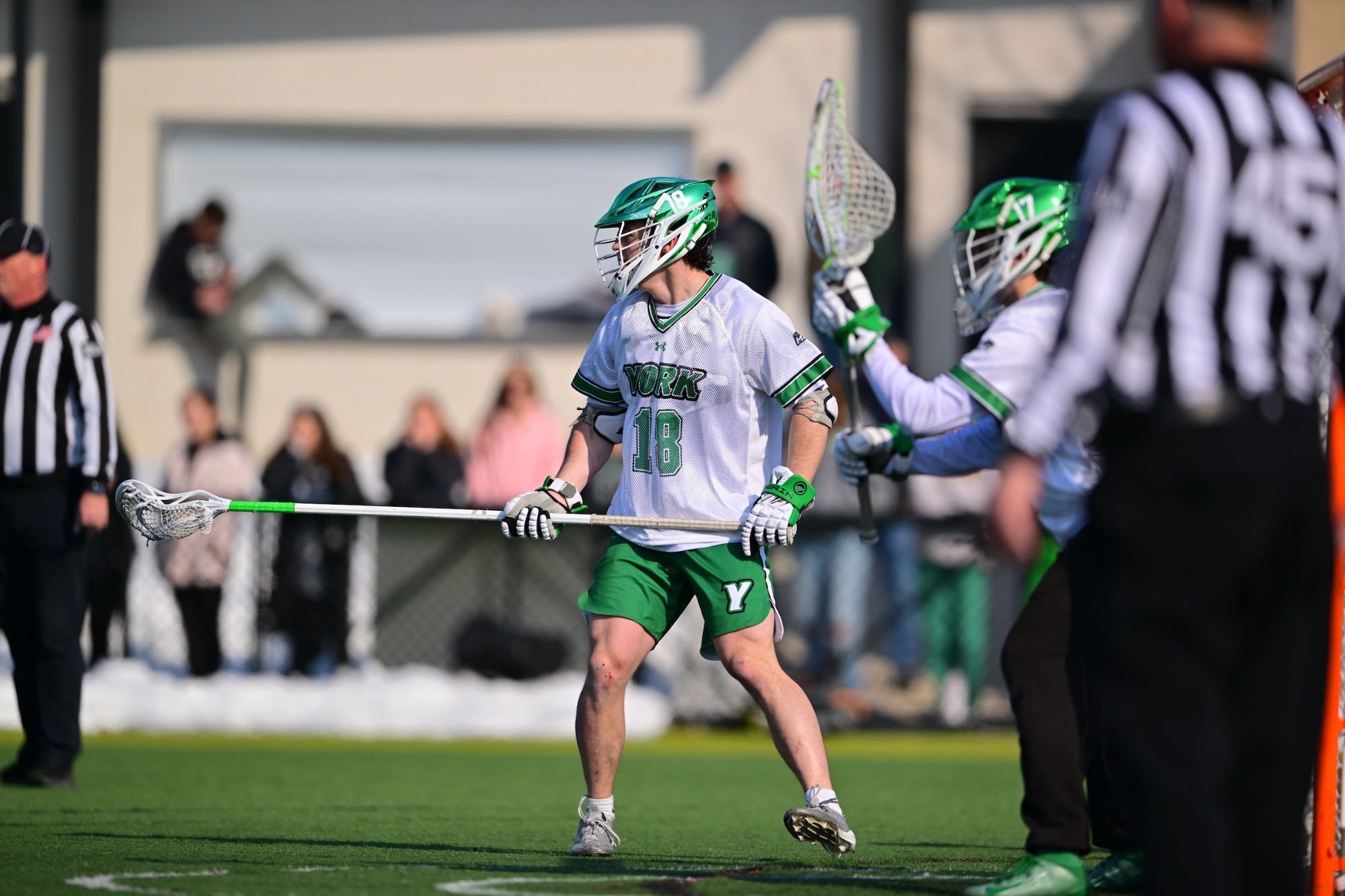male in white jersey holding lacrosse stick