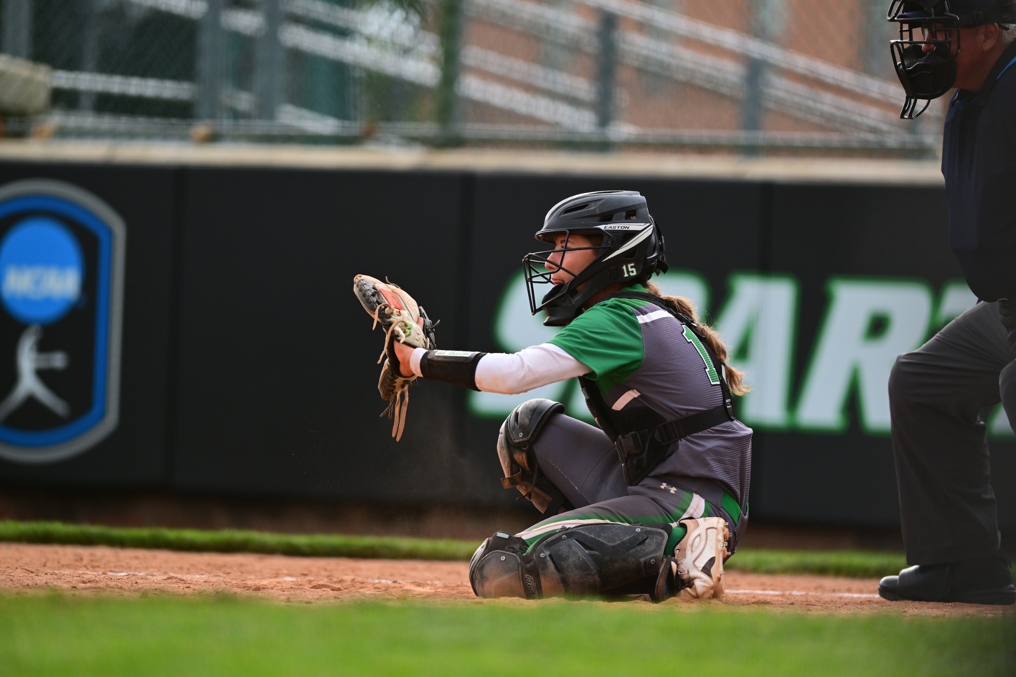 female in grey uniform in catcher's gear