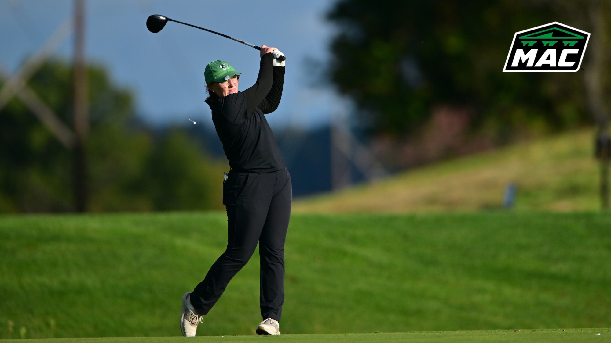 female golfer tracks tee shot with MAC logo in upper right corner