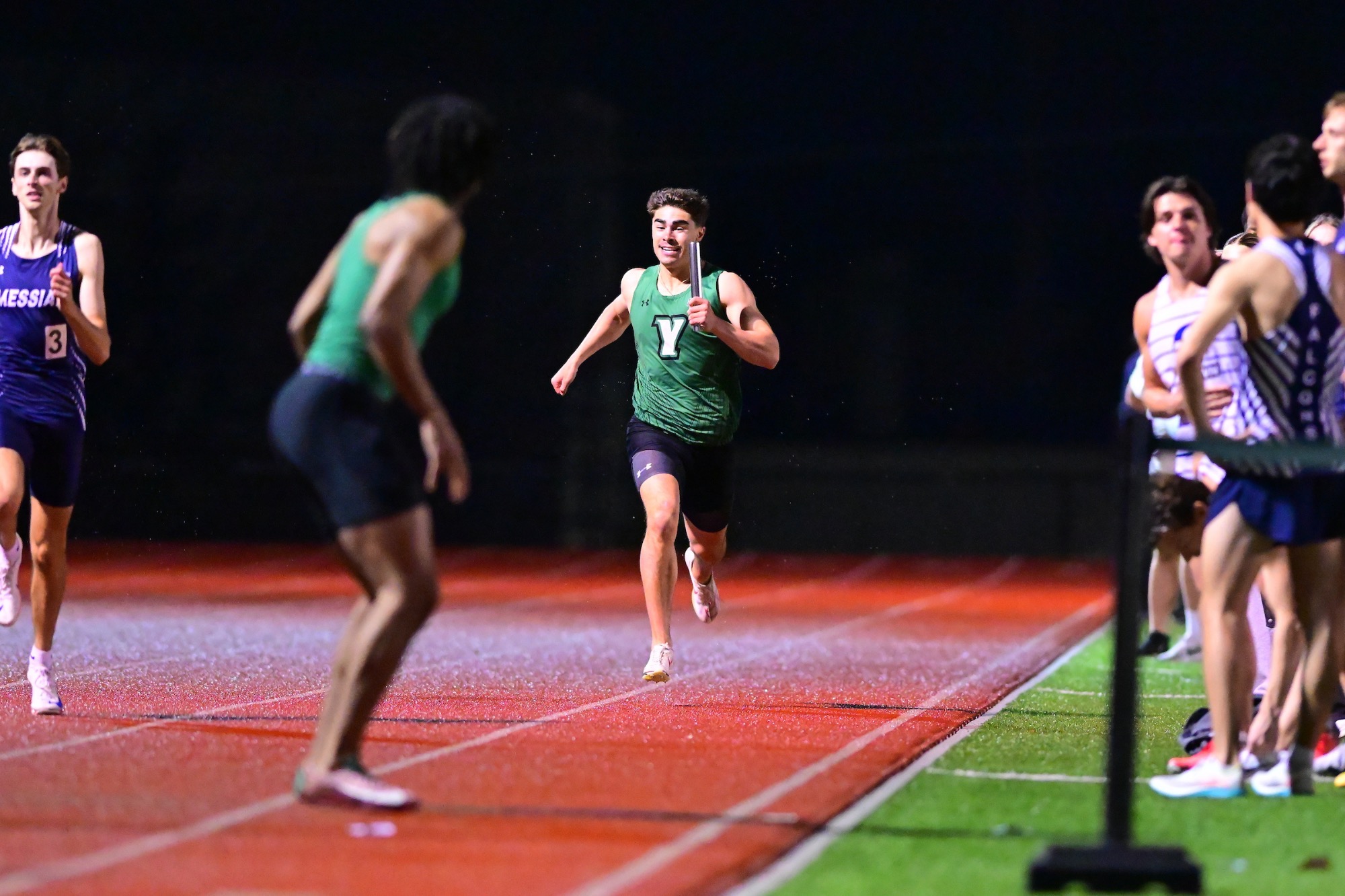 male running on track with baton
