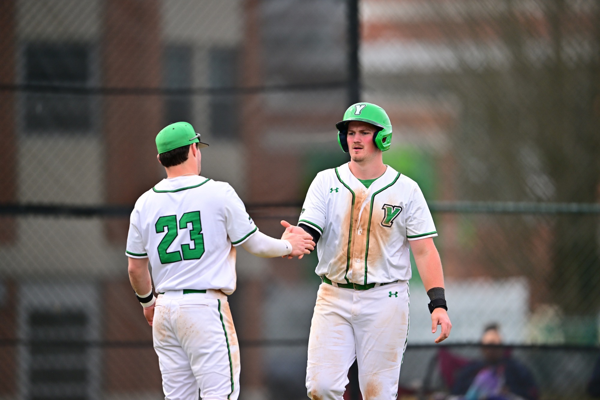 Two males in white uniforms giving a high five