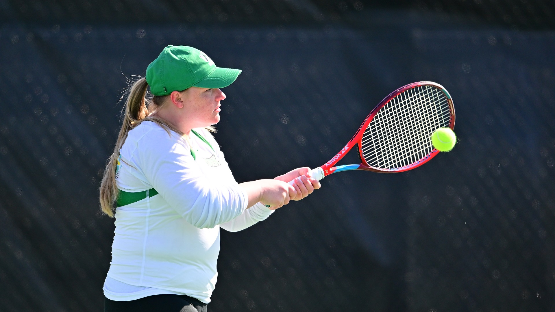 female tennis player hits ball
