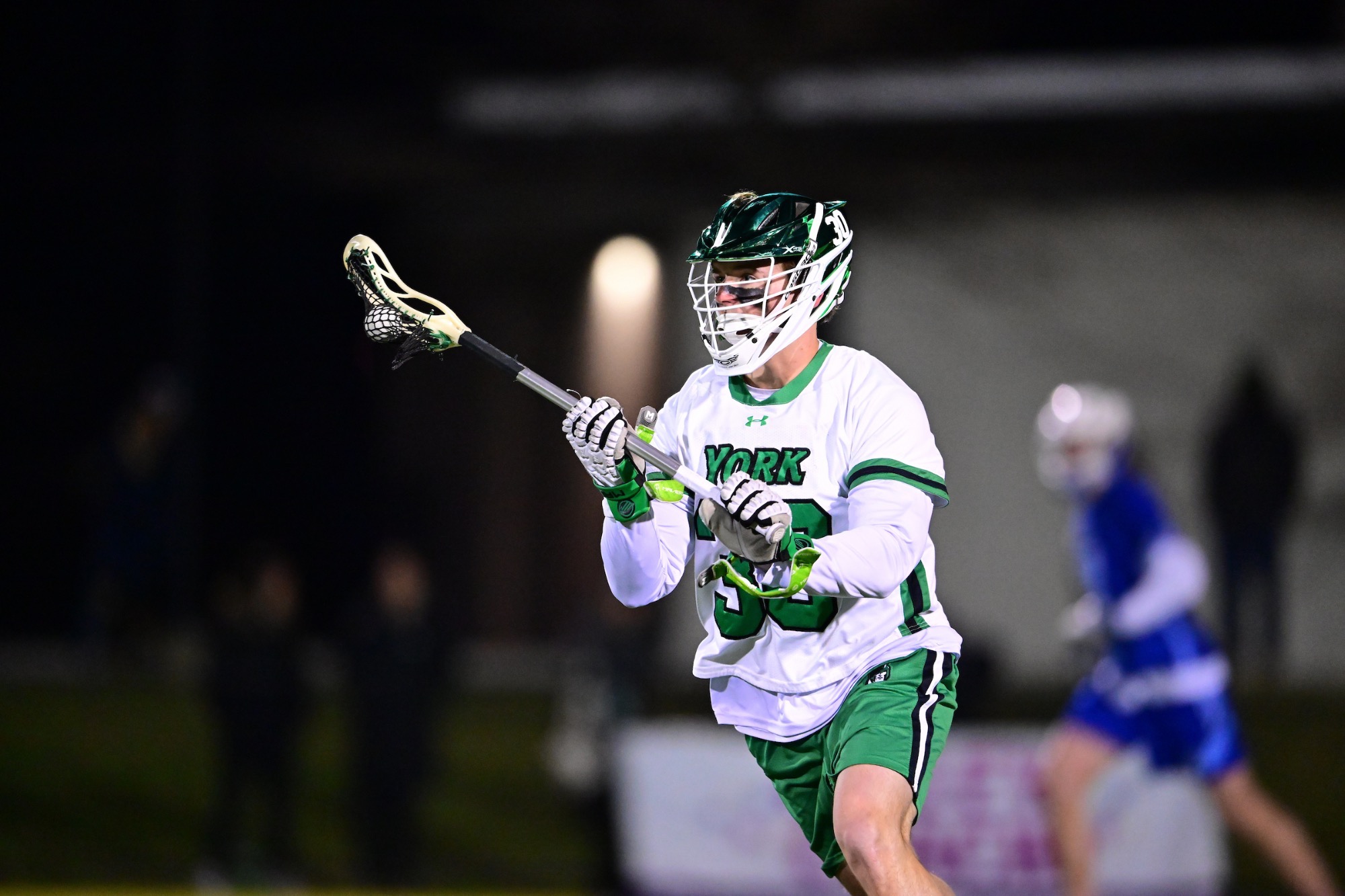 male in white uniform with lacrosse stick