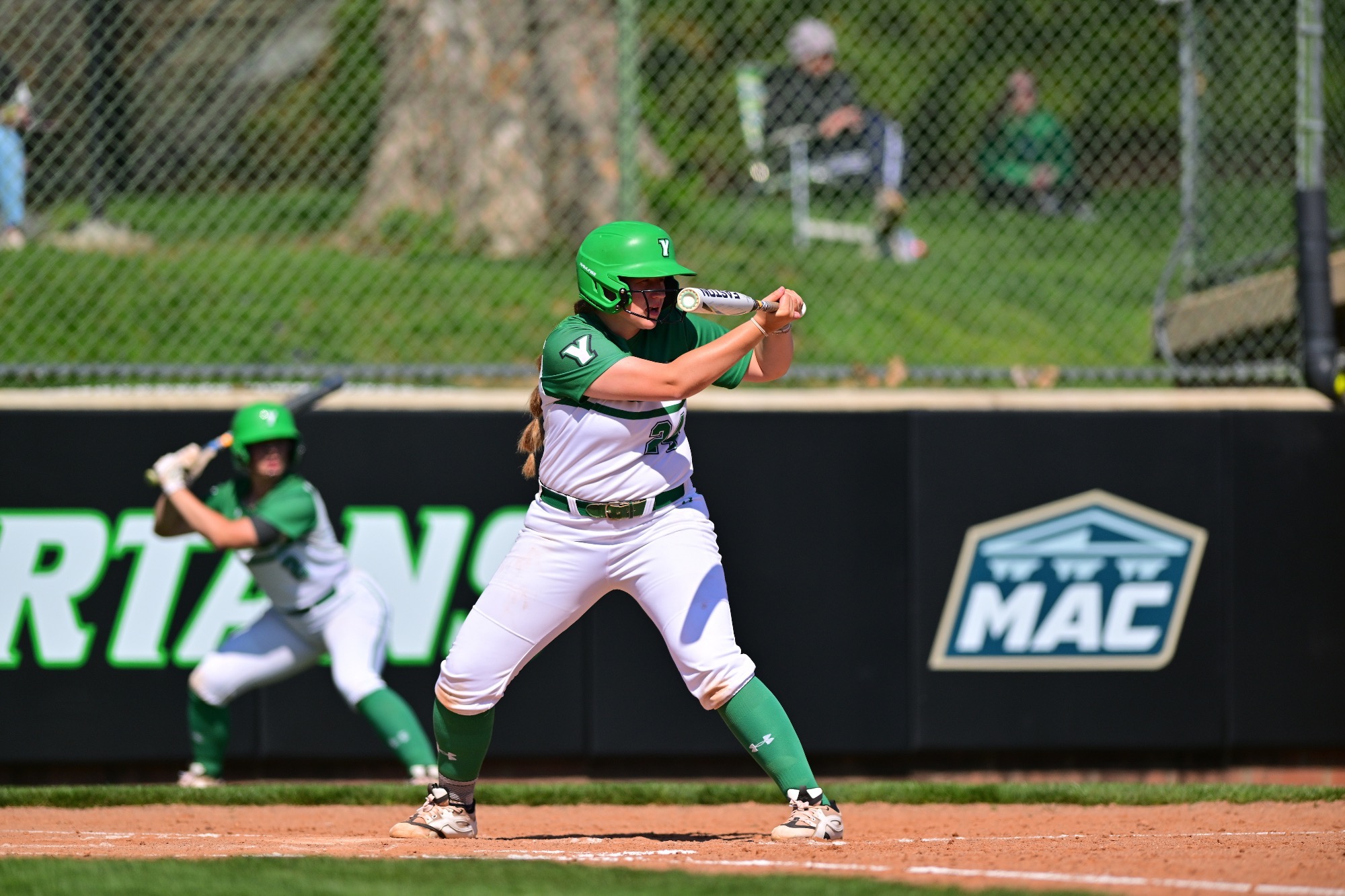 female in white jersey holding softball bat