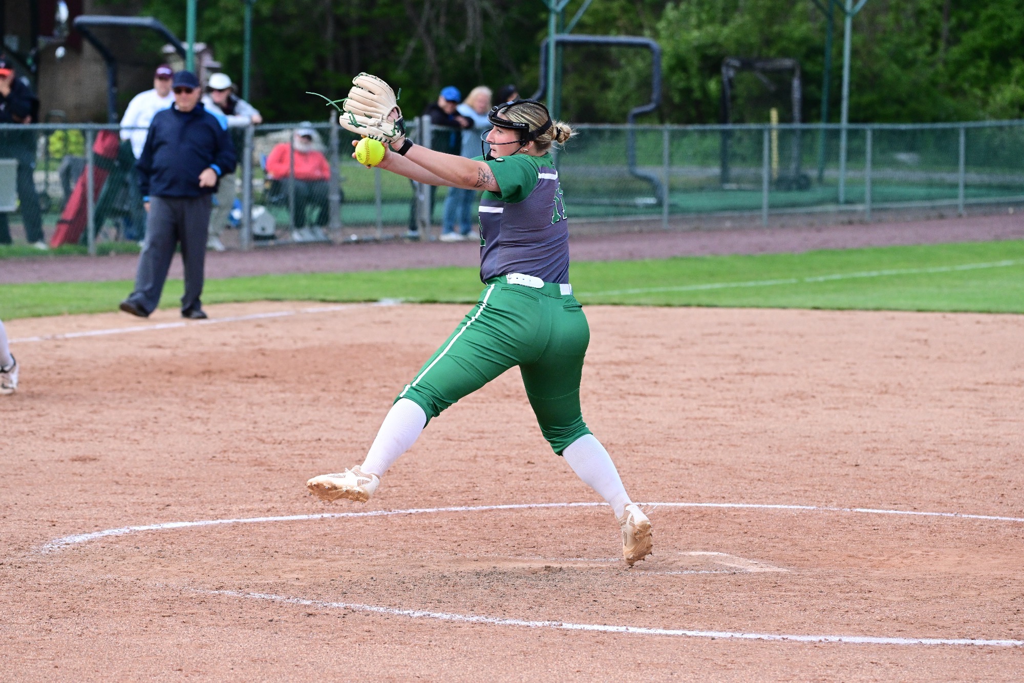 Female in grey uniform pitching a softball