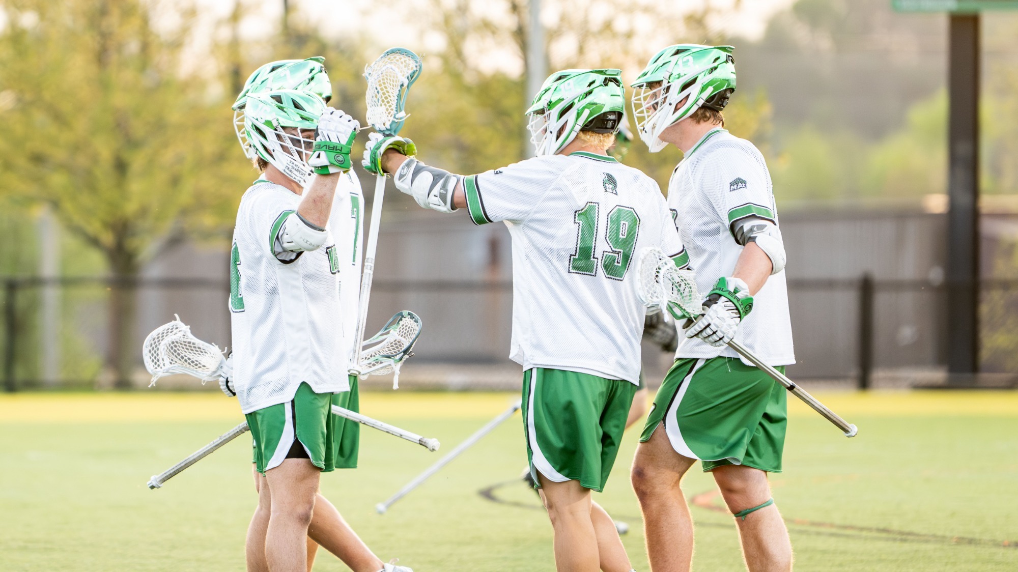men's lacrosse players celebrate after a goal