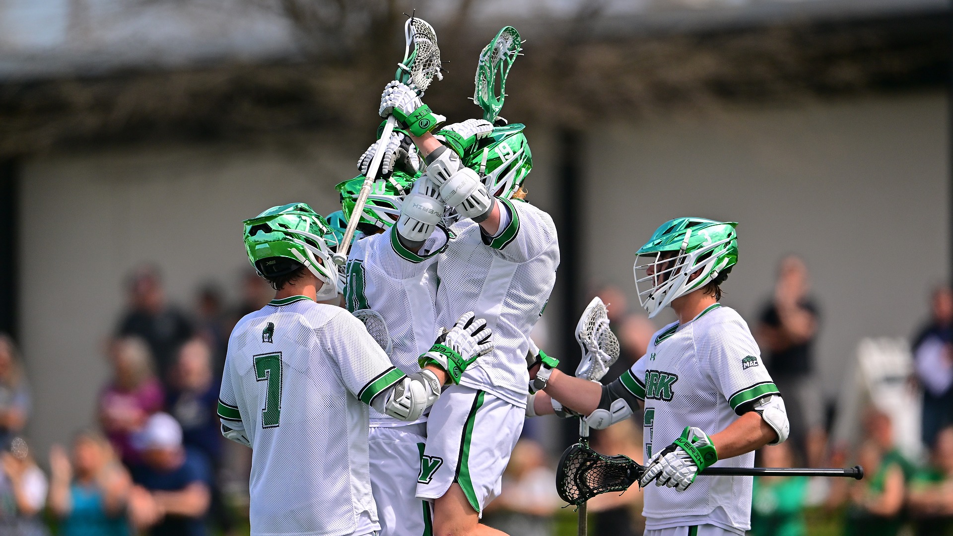 men's lacrosse players celebrate goal