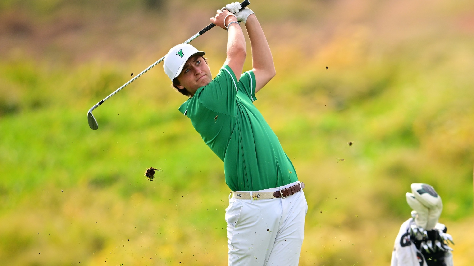 male golfer green shirt swings club