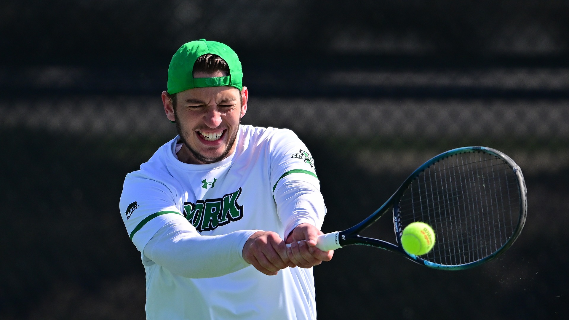 male tennis player hits ball