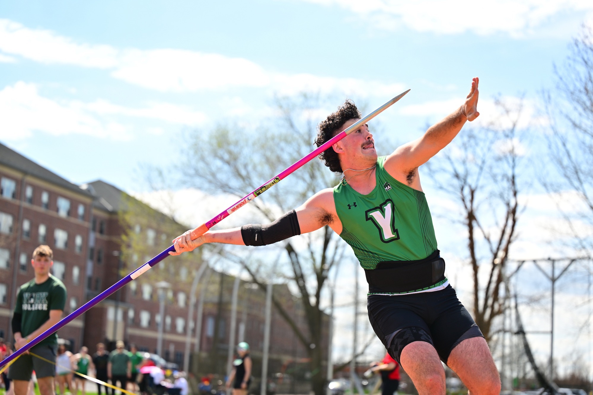 Male in green shirt throwing javelin 