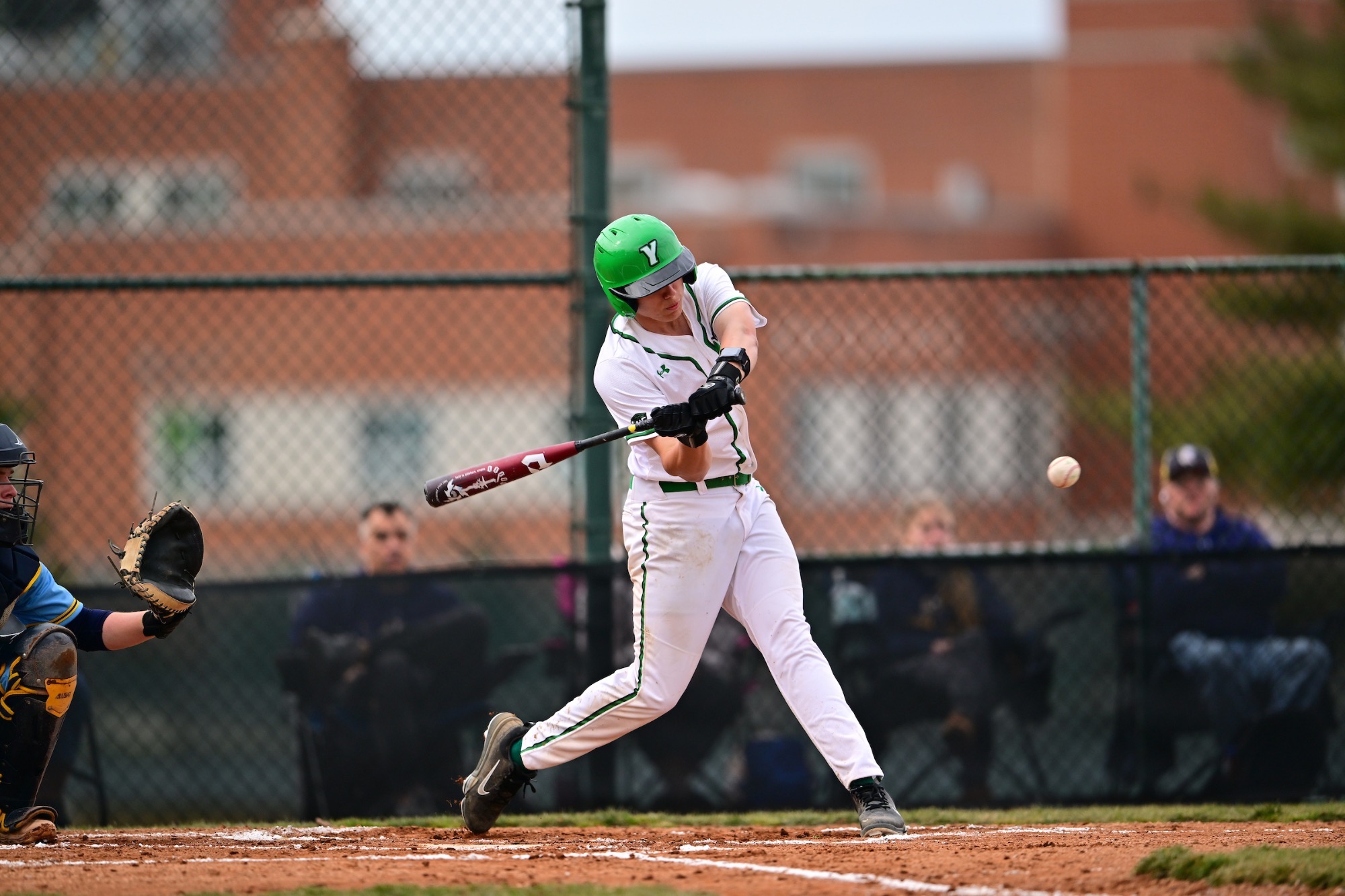Baseball player in white uniform swinging bat