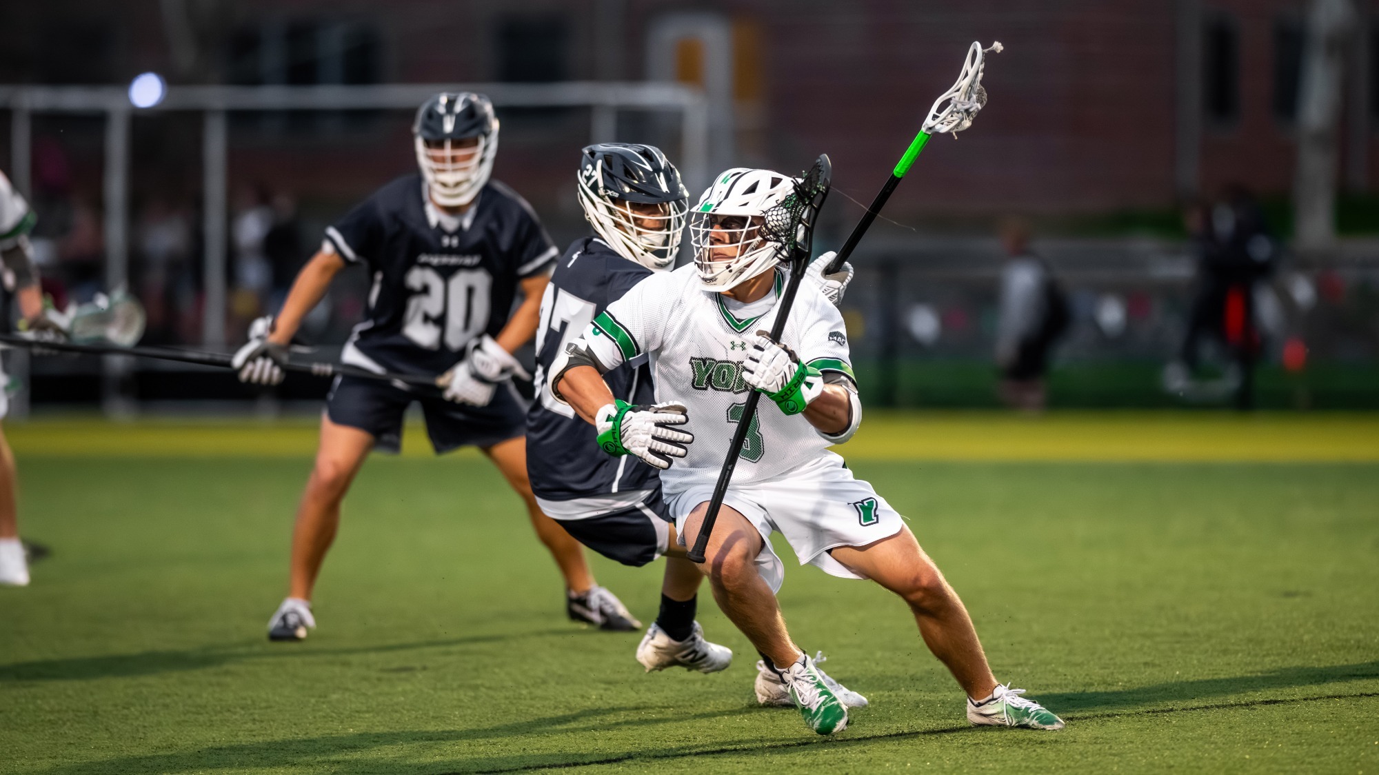 male lacrosse player maneuvers past defender