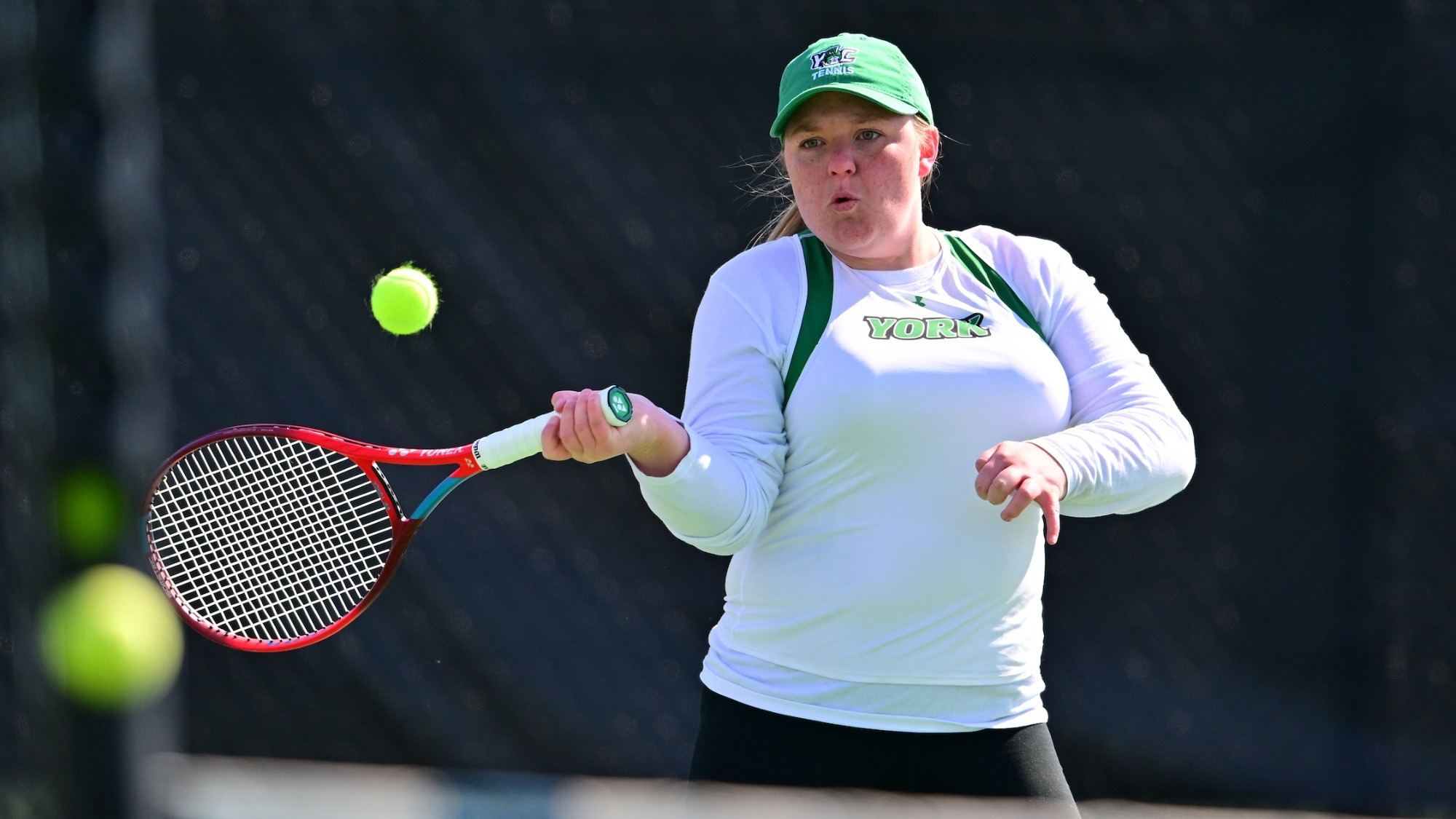 female tennis player hits ball