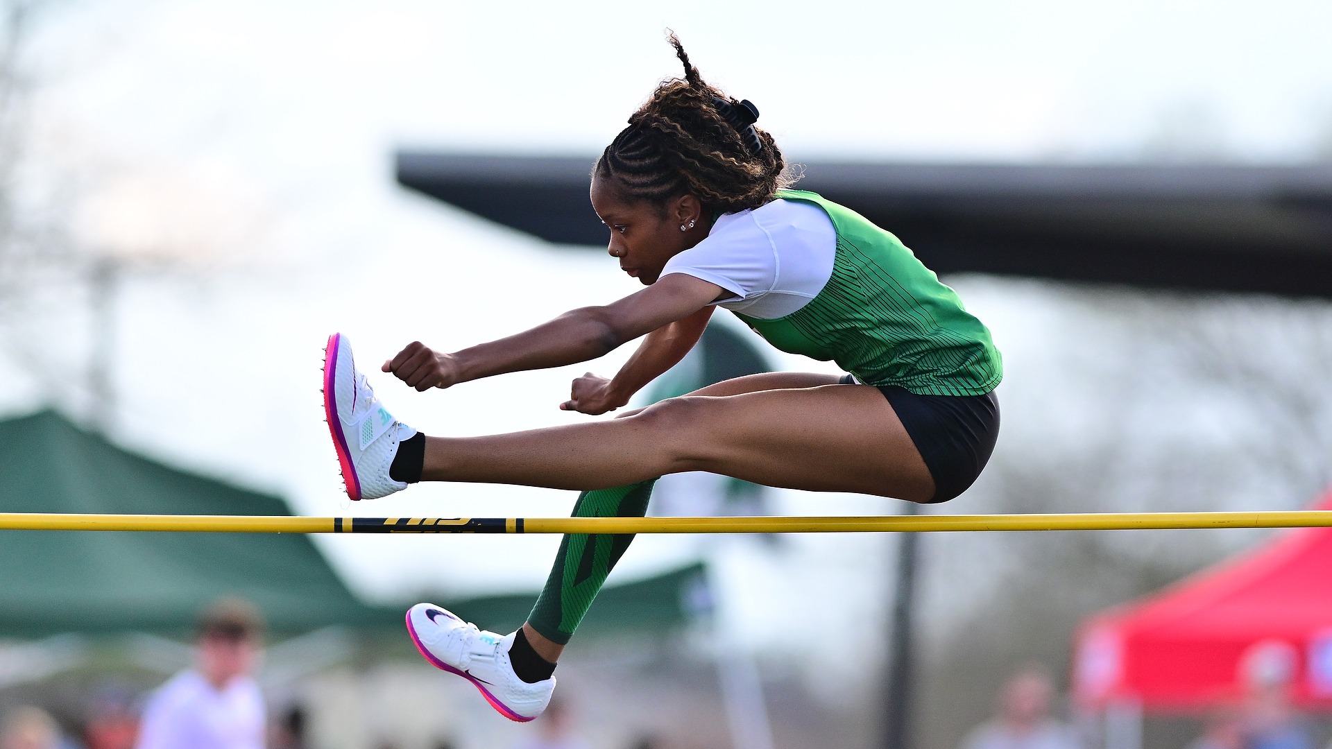 female high jumper leaps over bar