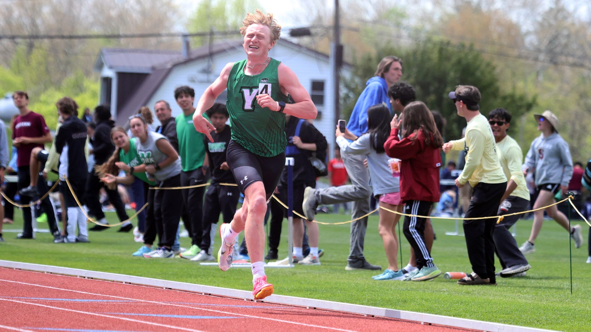 male track athlete runs towards finish line
