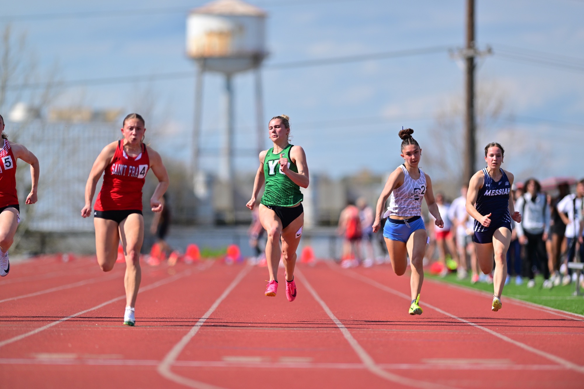Female in green running on track