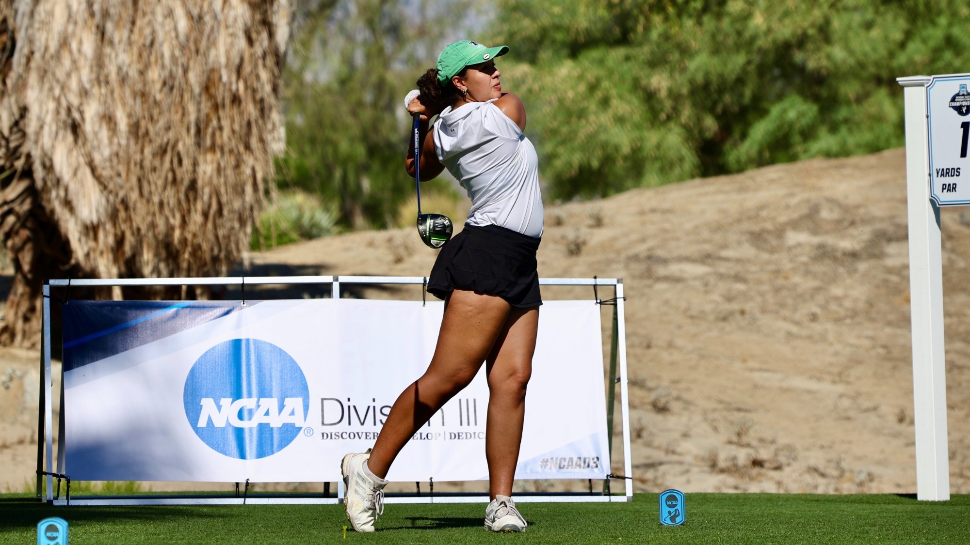female golfer eyes tee shot
