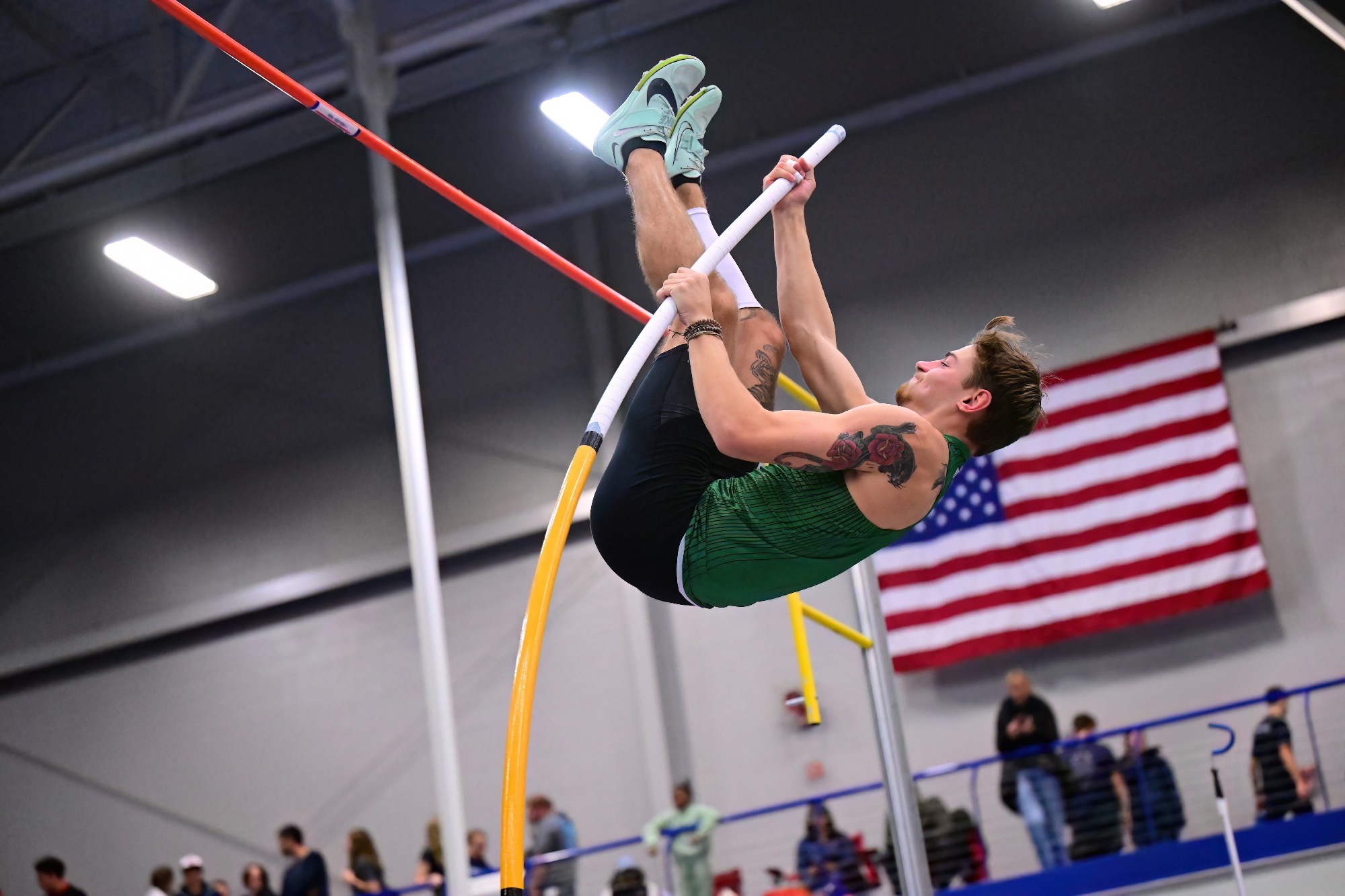 male jumping over pole