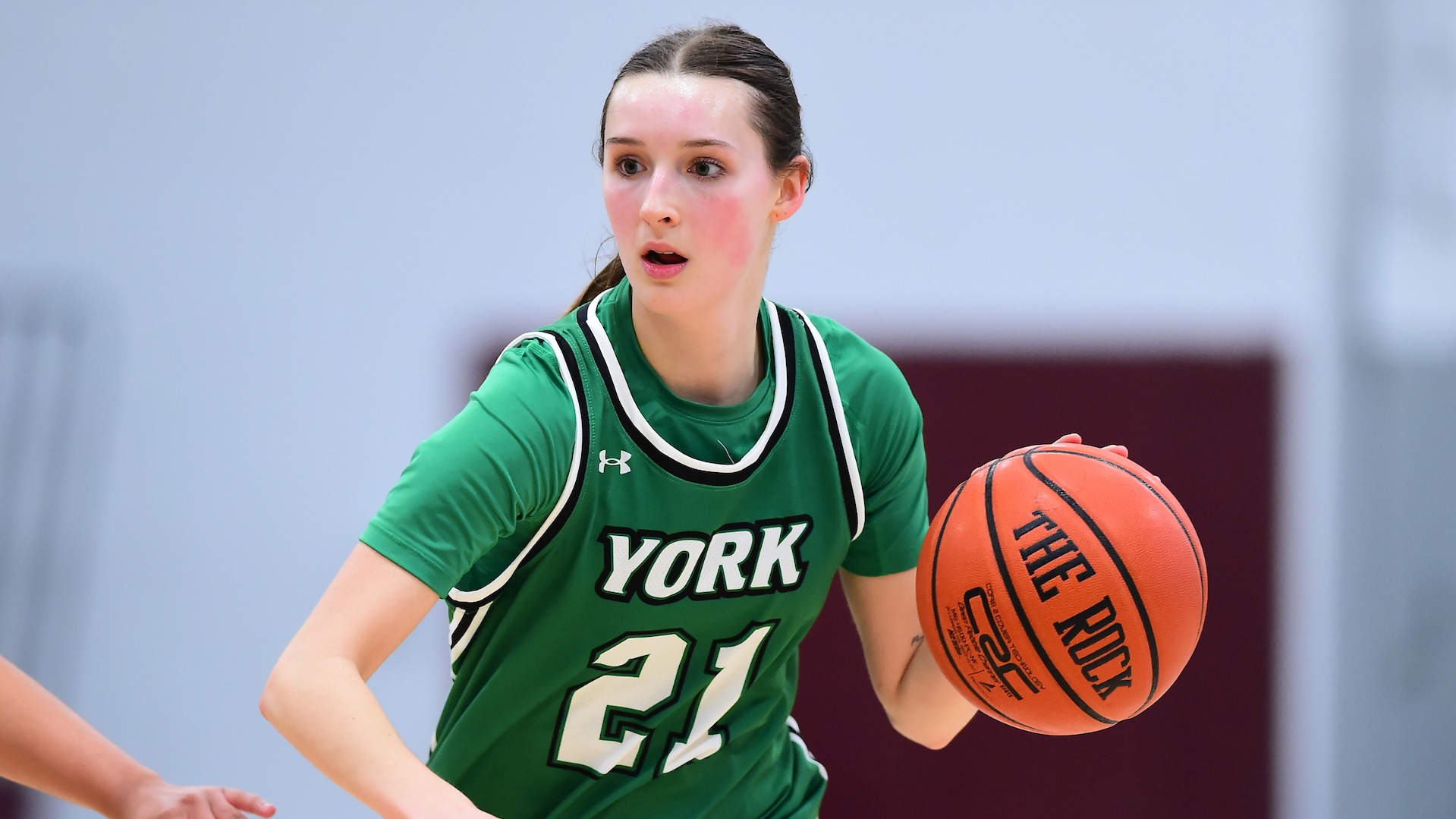 female basketball player dribbles to her left
